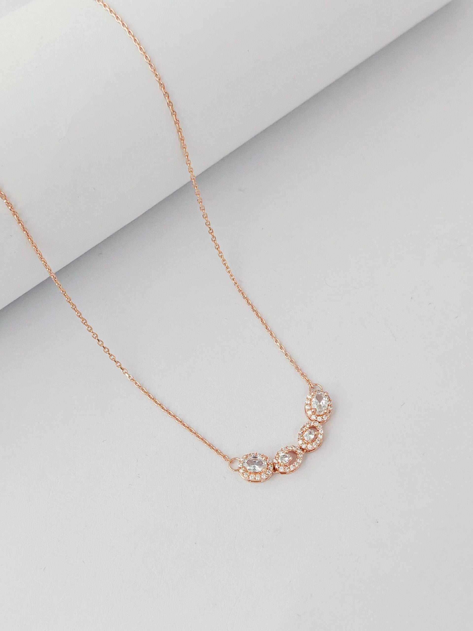 Rose gold necklace with a subtle design on a light gray background