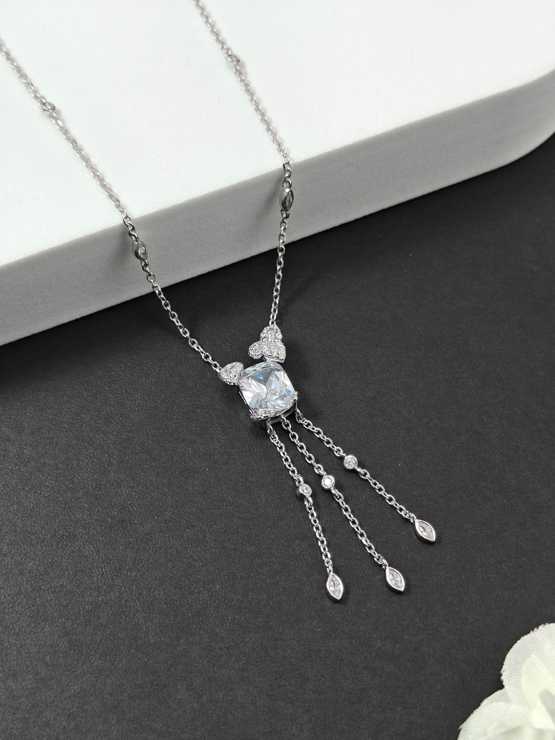 Silver necklace with a central pendant on a dark surface
