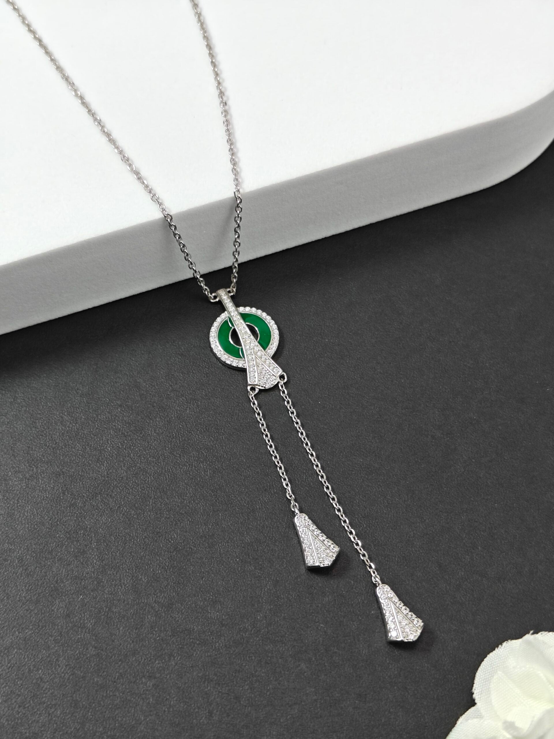 Silver necklace with pendant on a gray surface