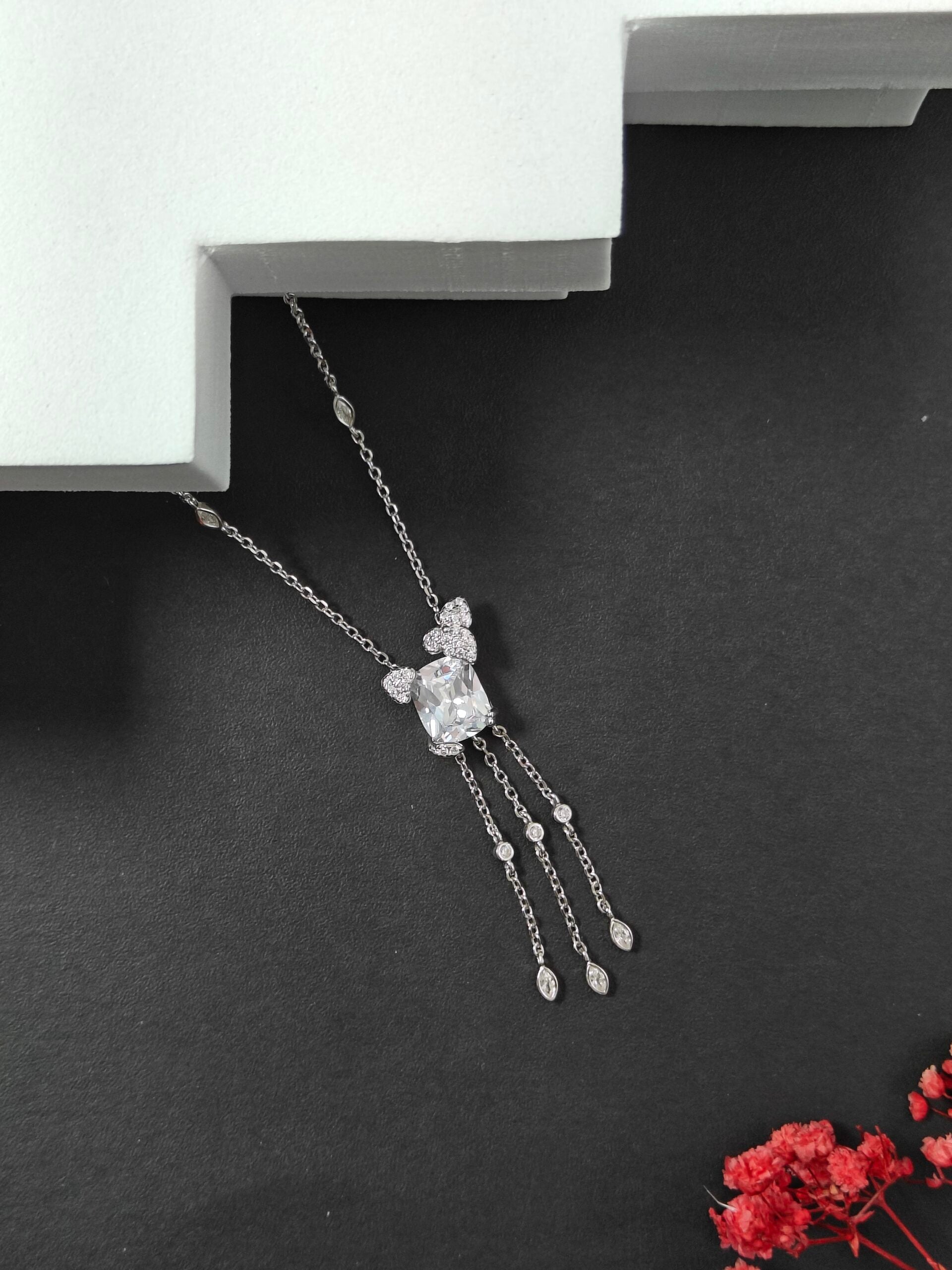 Silver necklace with a pendant on a dark surface