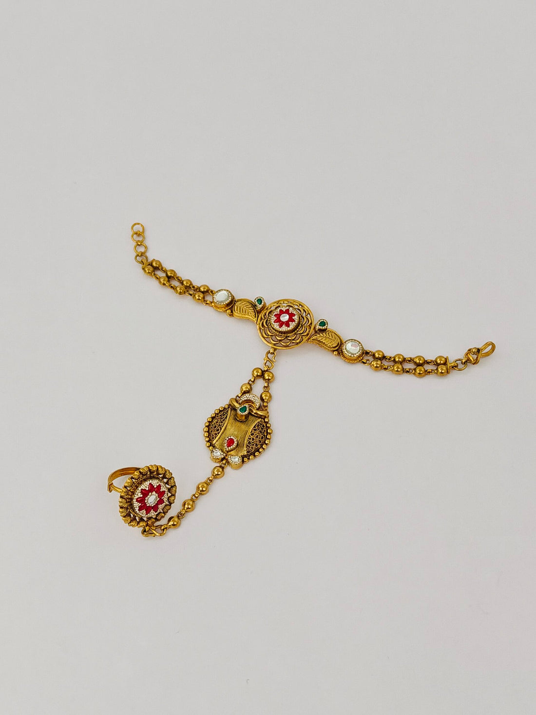 Gold bracelet with decorative elements on a light gray background