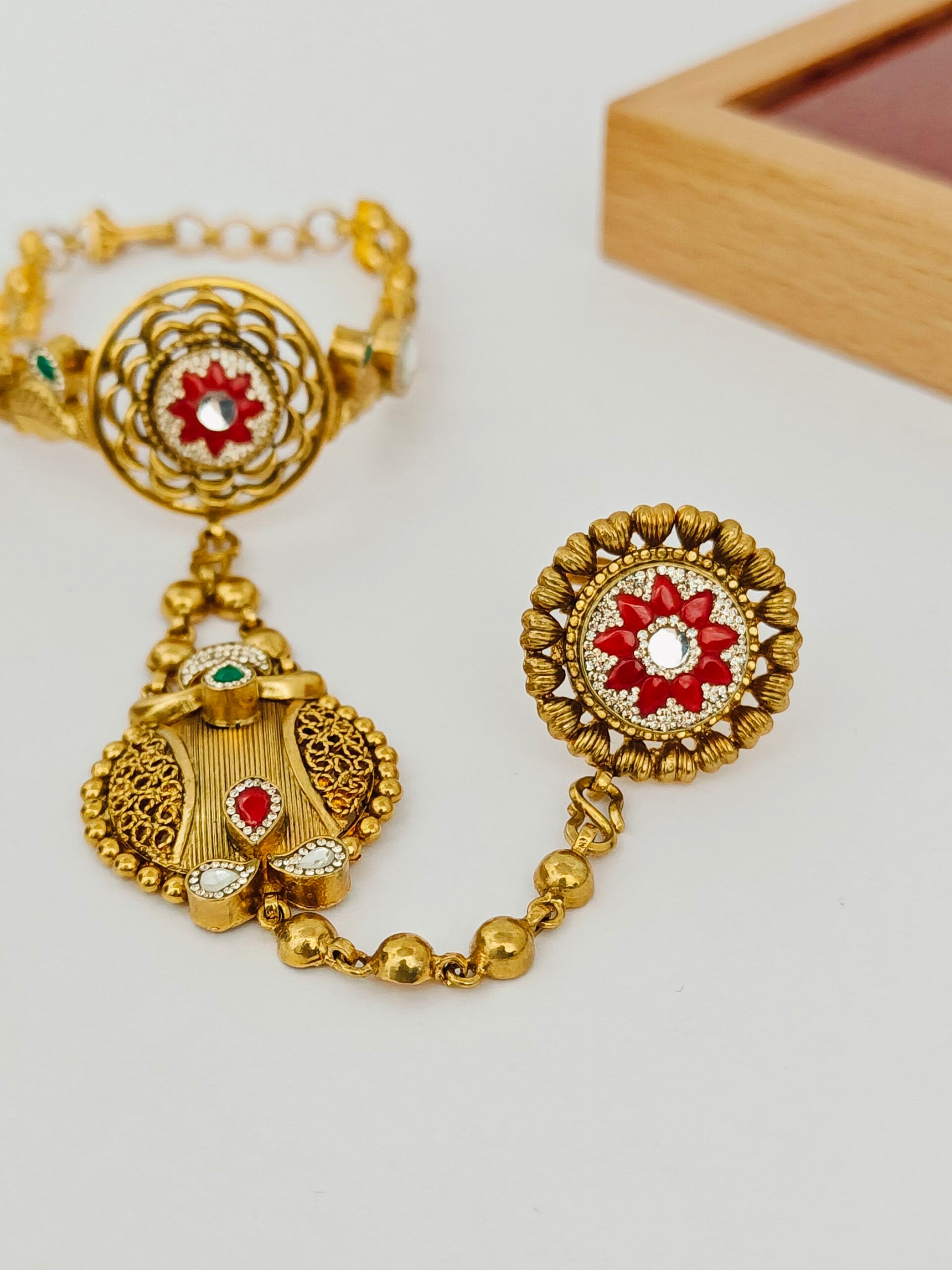 Gold jewelry set with earrings and bracelet on a light background