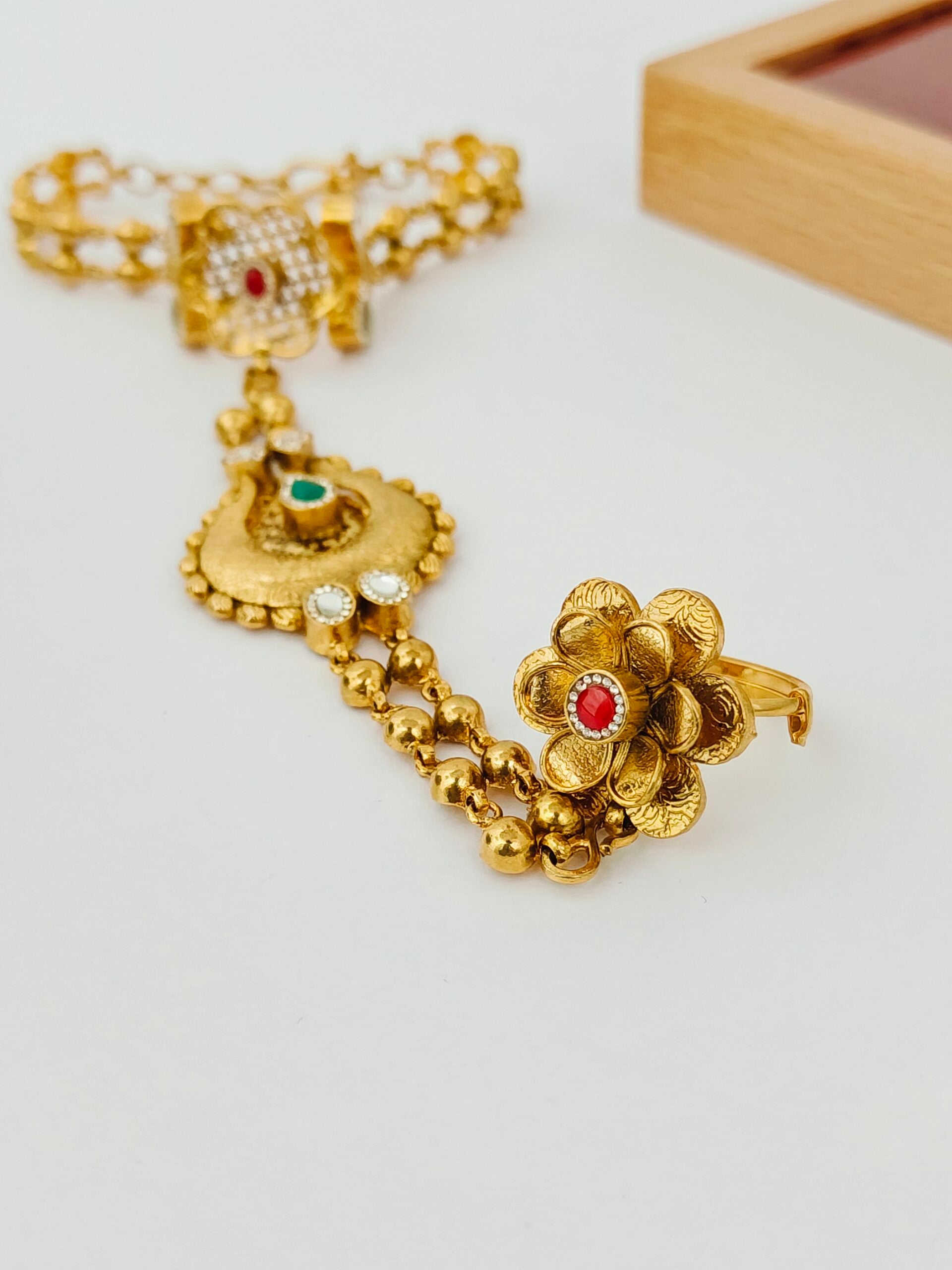 Gold bracelet with floral design on a white surface