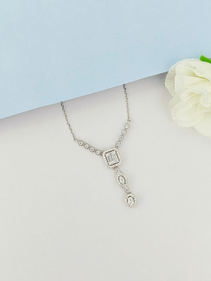 Silver necklace with a pendant on a mannequin bust against a light blue background