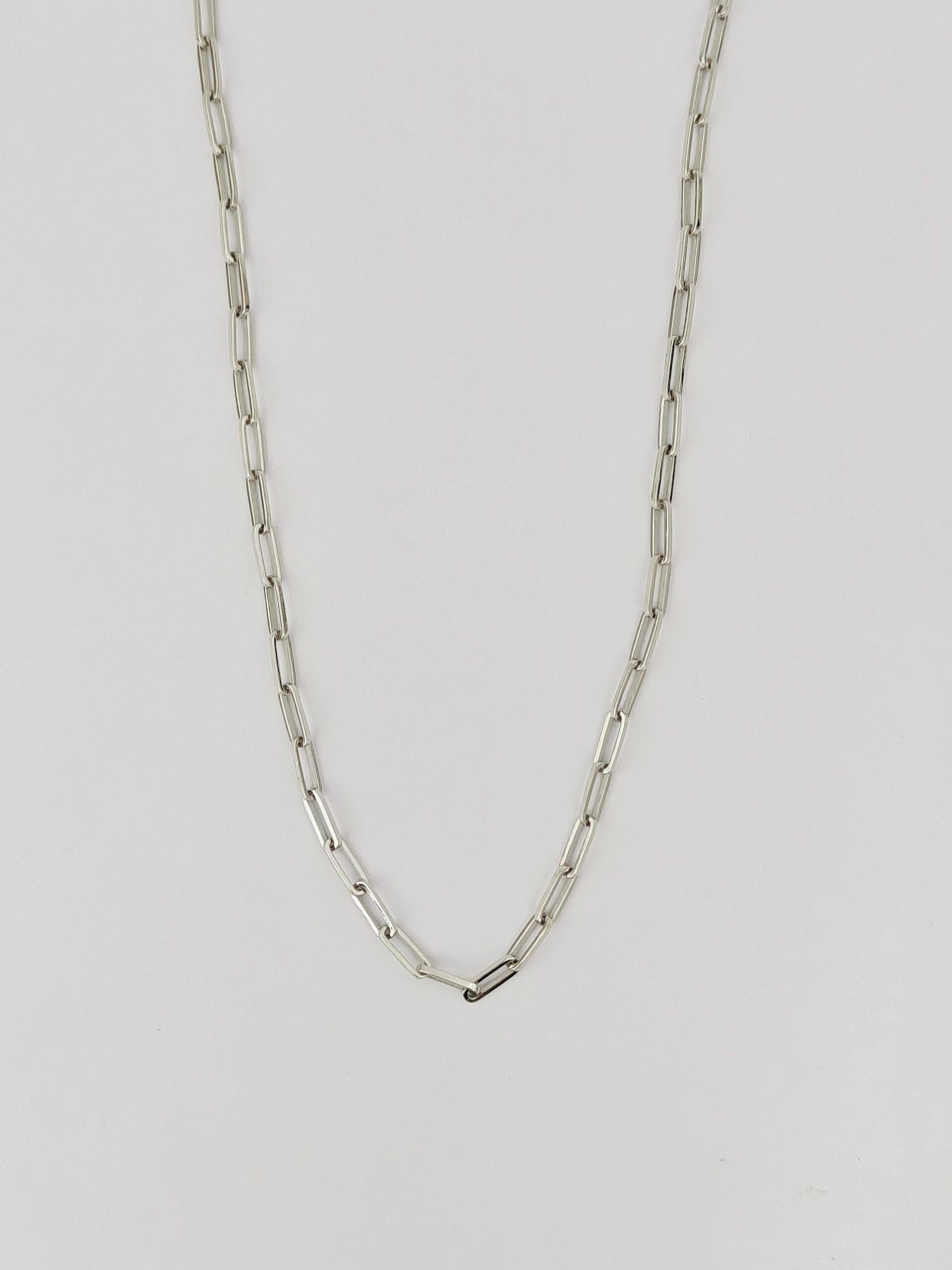 Silver chain necklace on a light gray background
