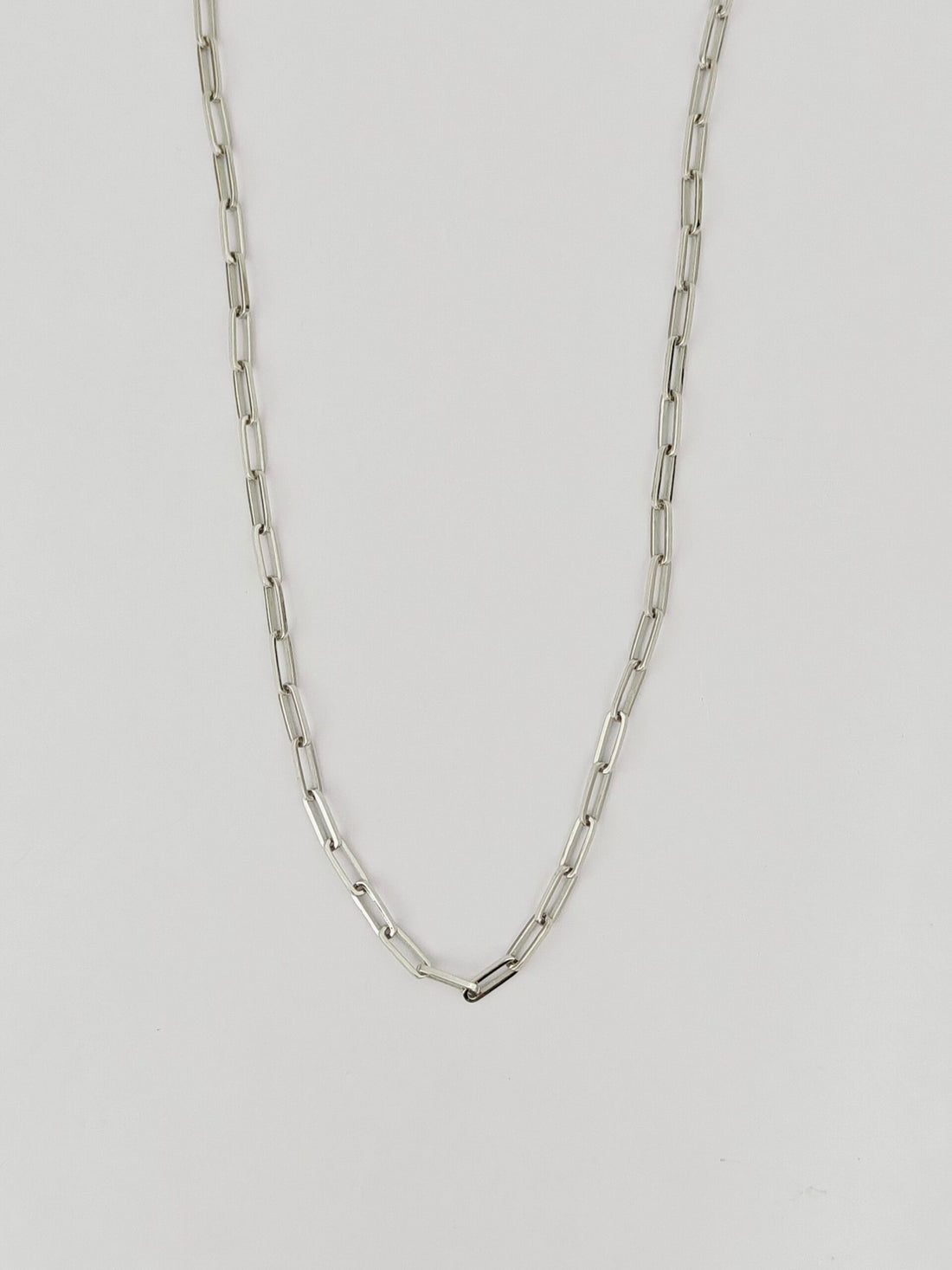 Silver chain necklace on a light gray background