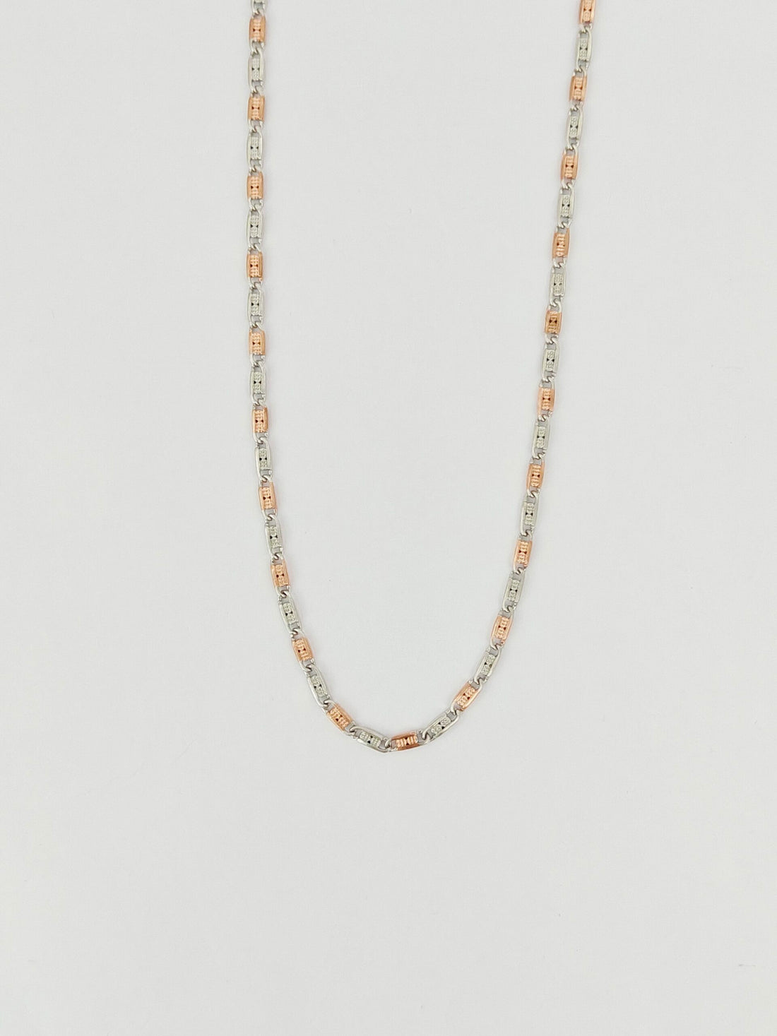 Necklace with alternating silver and rose gold beads on a light gray background