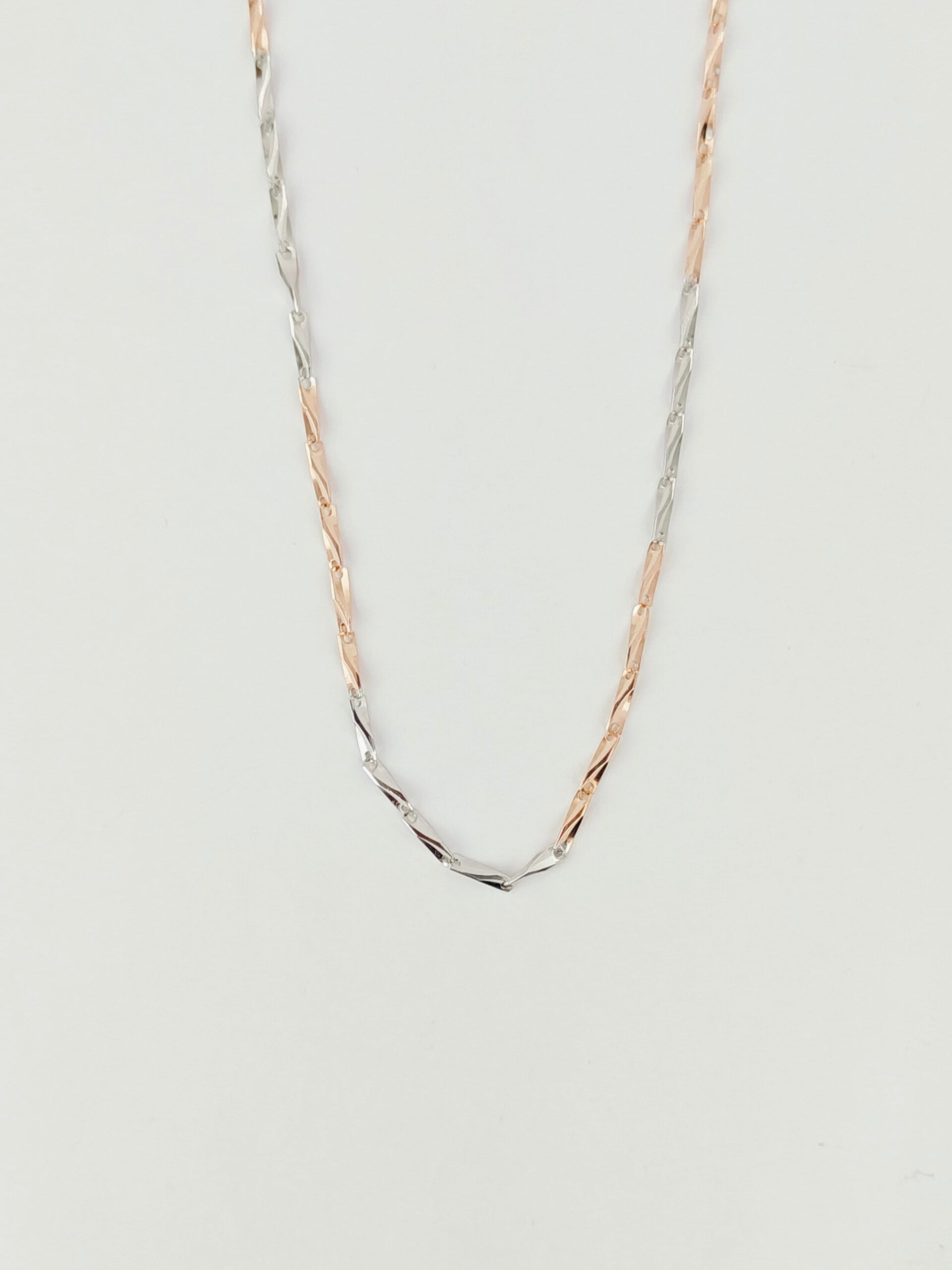 Two gold necklaces on a light gray background