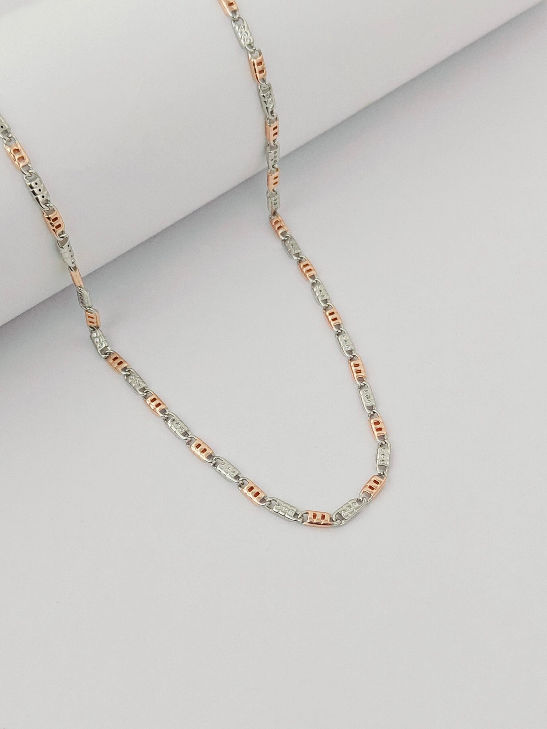 Three-strand necklace with silver, rose gold, and white gold links on a light gray background
