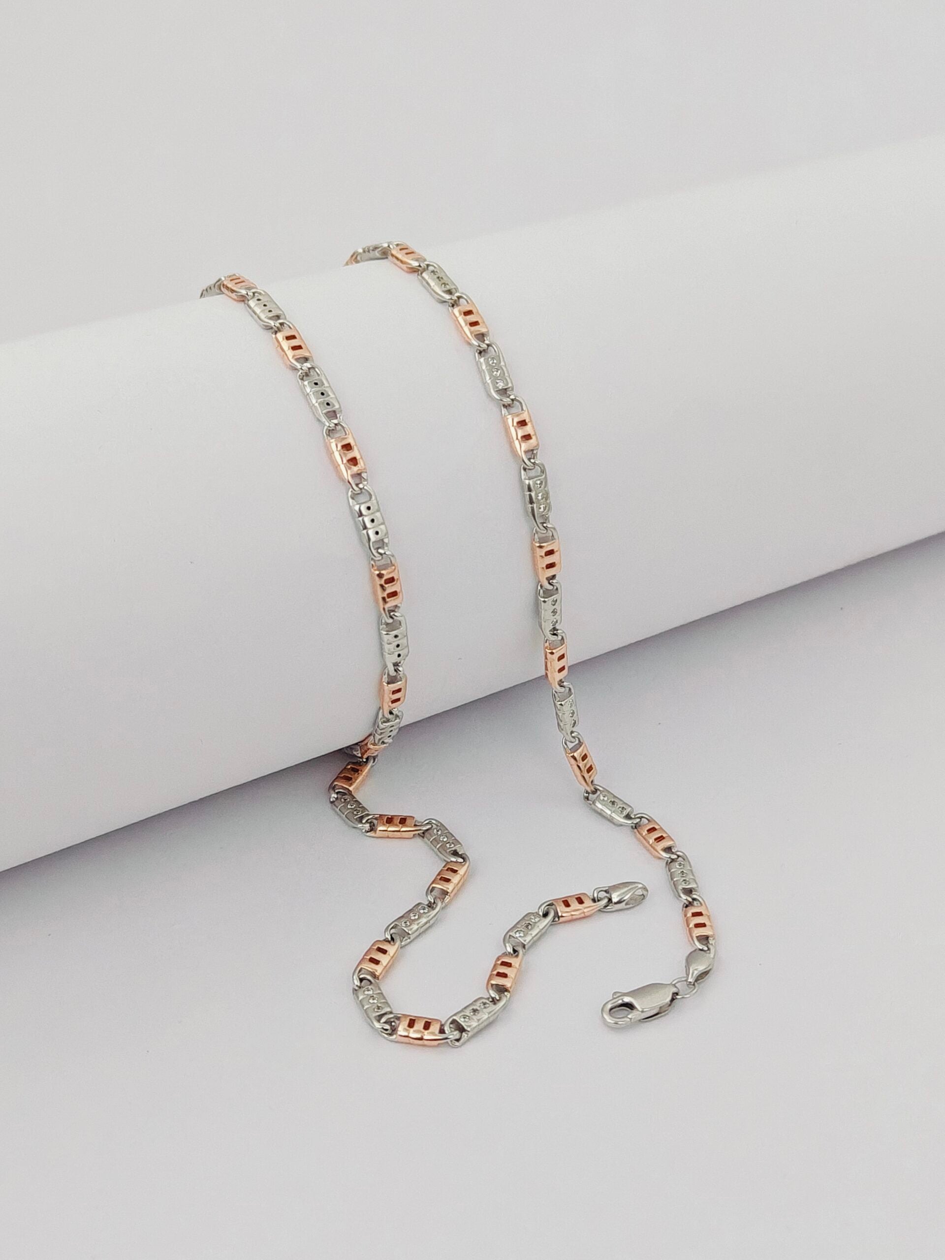 Two-tone chain necklace on a light gray surface
