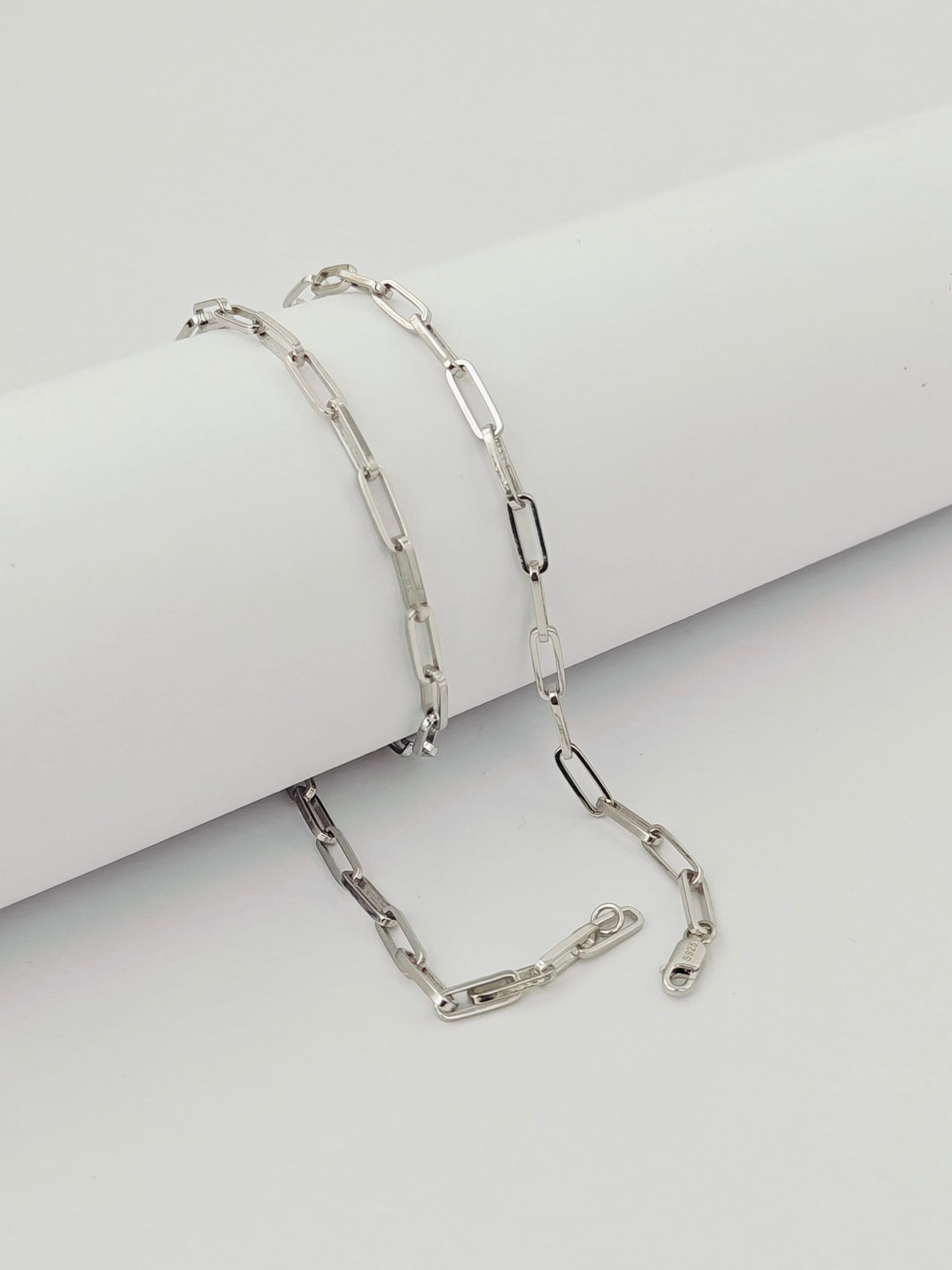 Silver chain bracelet on a light gray surface