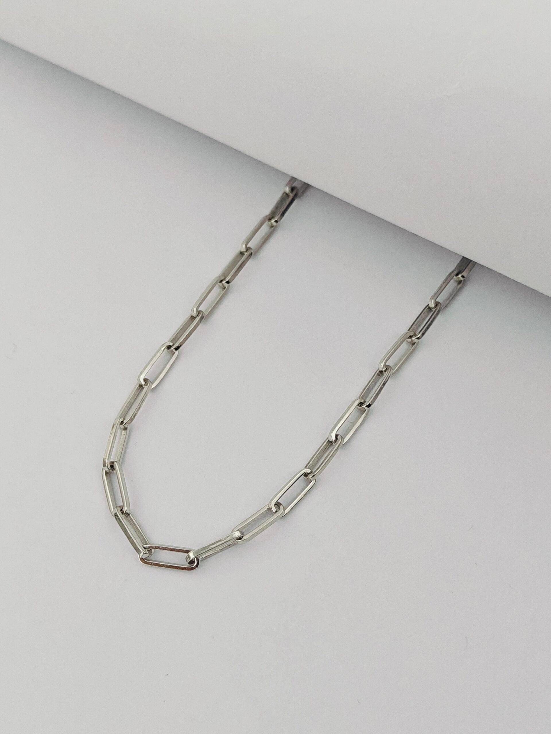 Silver chain necklace on a light gray background