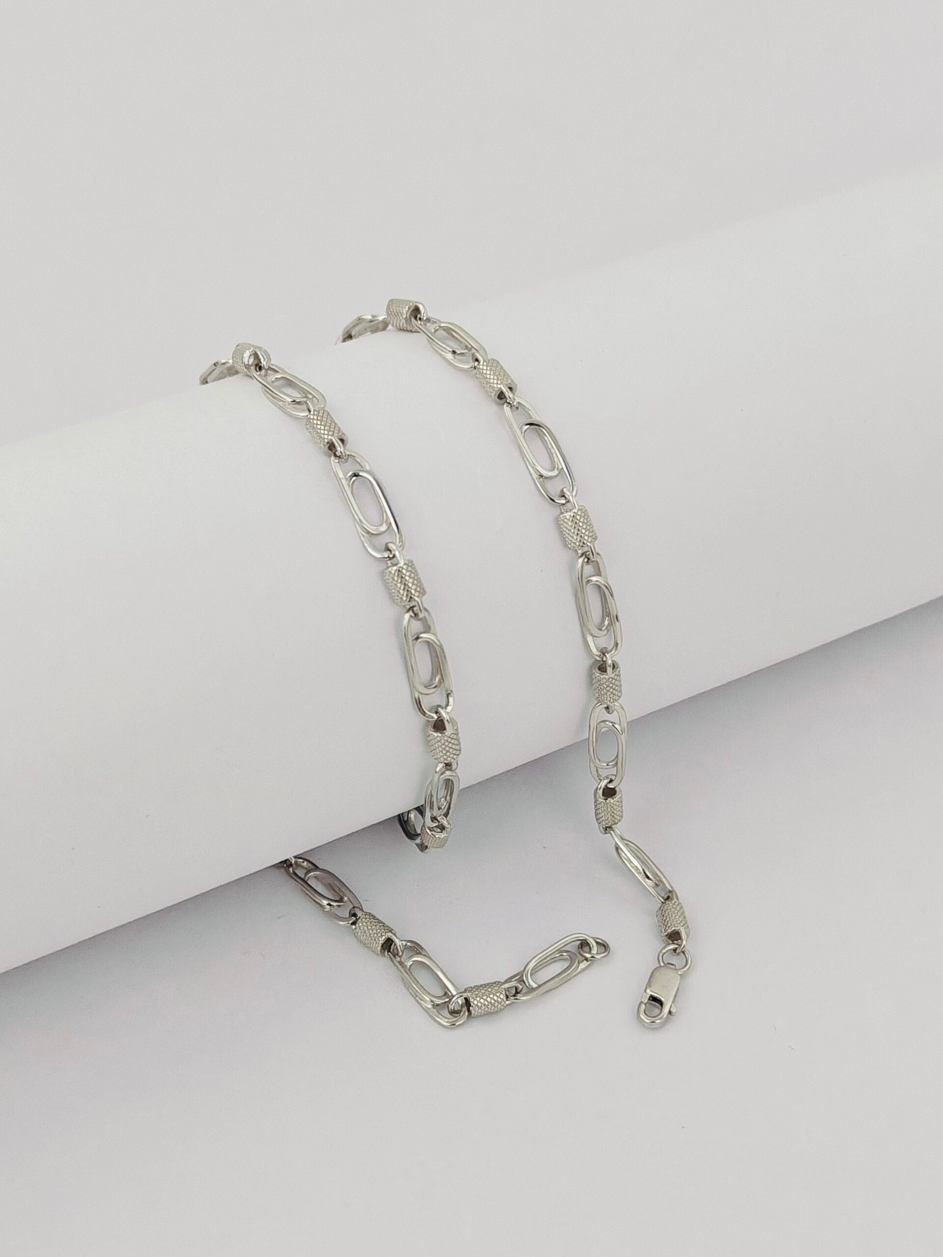 Silver chain bracelet on a light gray background
