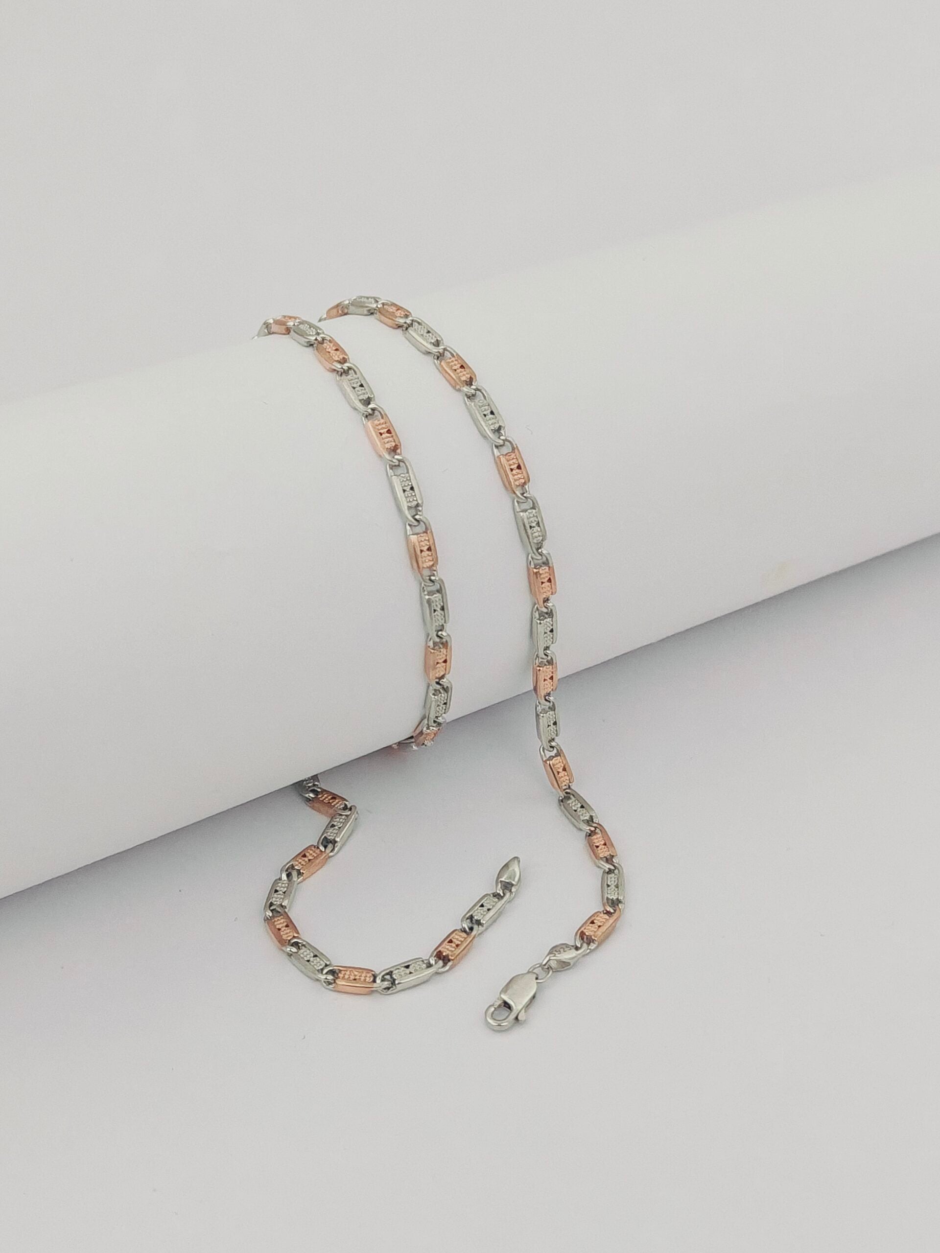 Two silver and rose gold necklaces on a light gray background