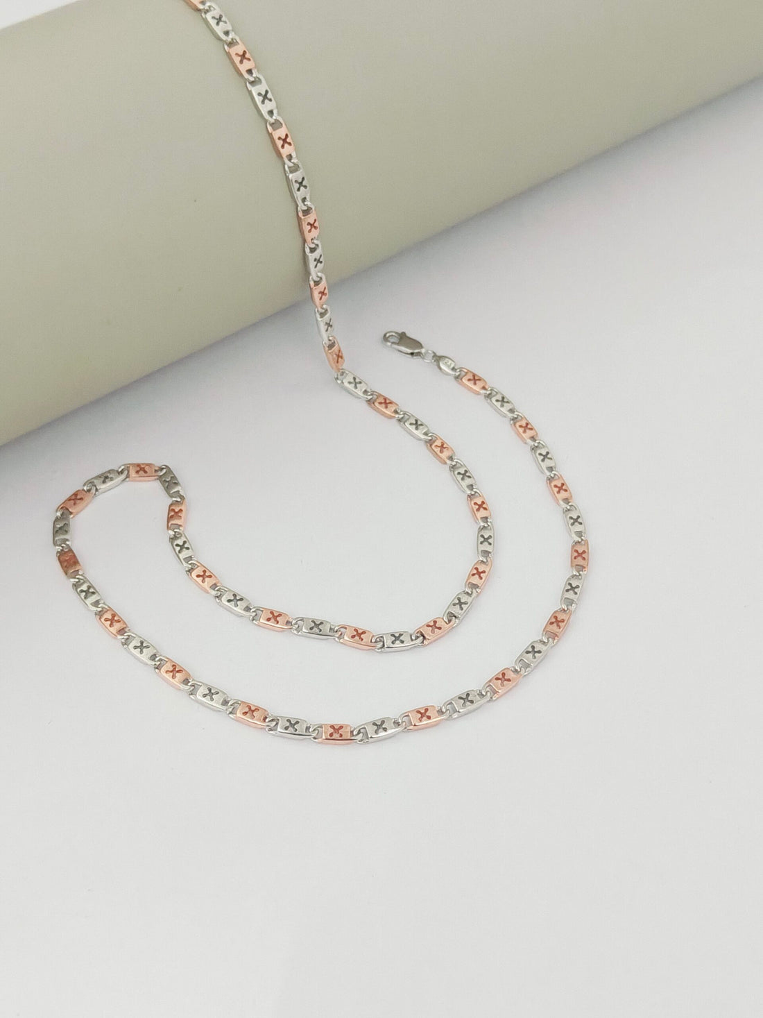 Multicolored chain necklace on a light gray surface