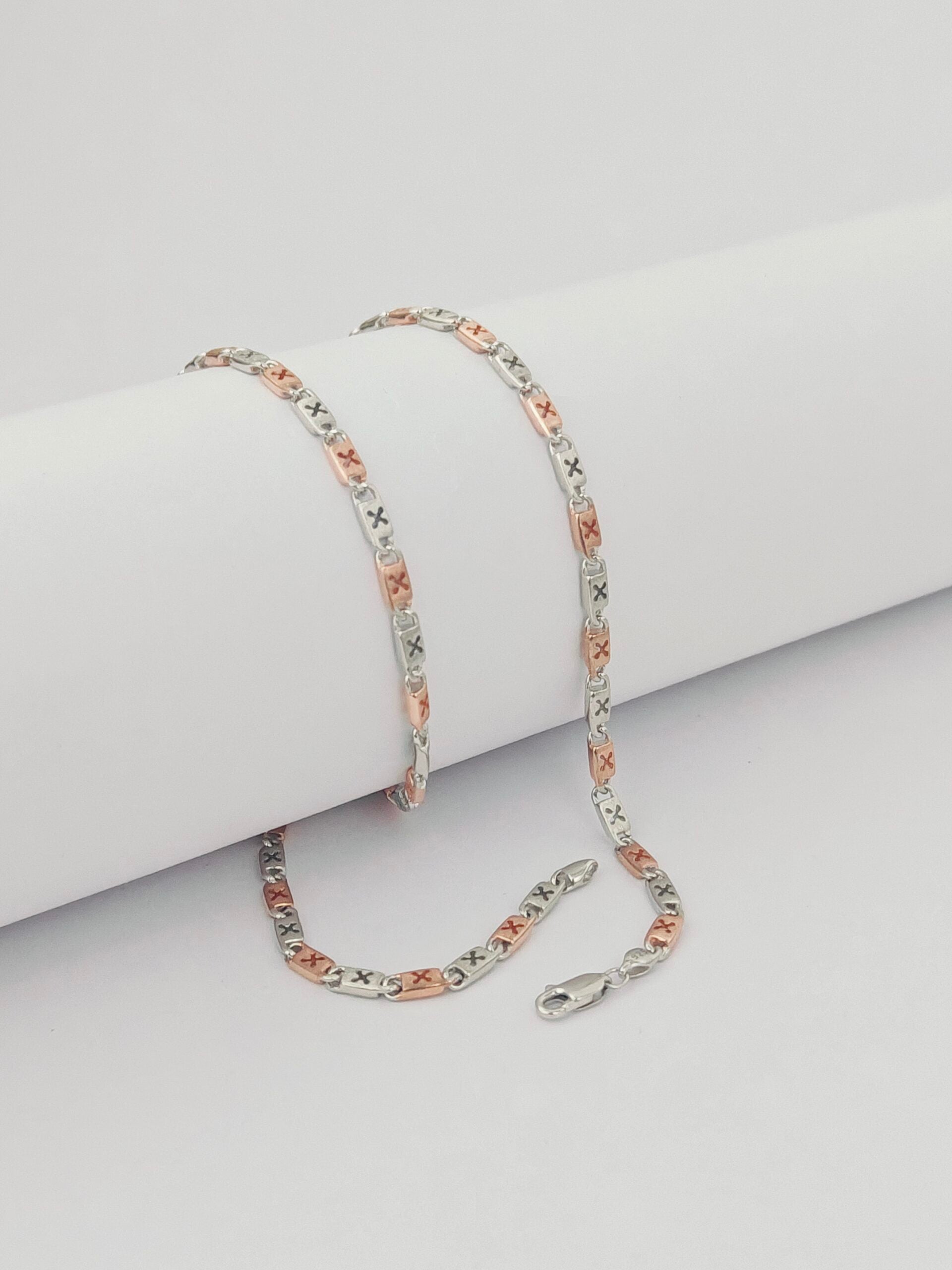 Two-tone chain necklace on a light gray surface