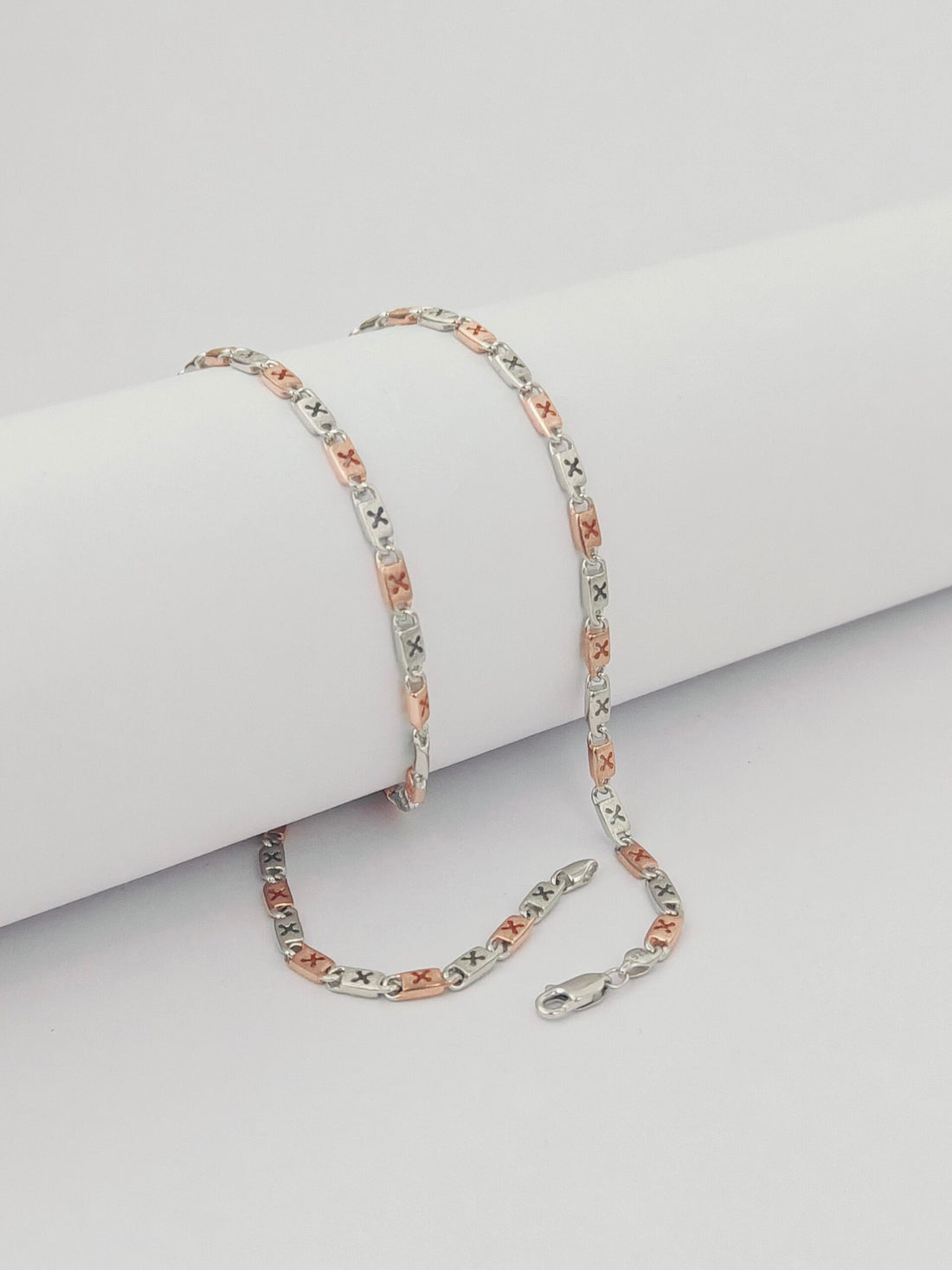 Two-tone chain necklace on a light gray surface