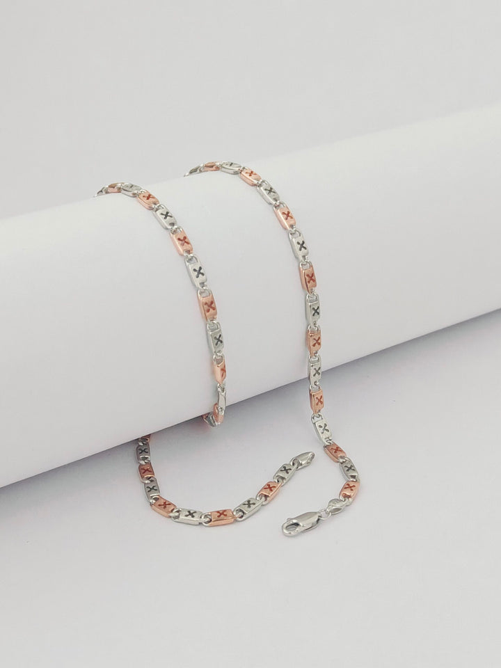 Two-tone chain necklace on a light gray surface