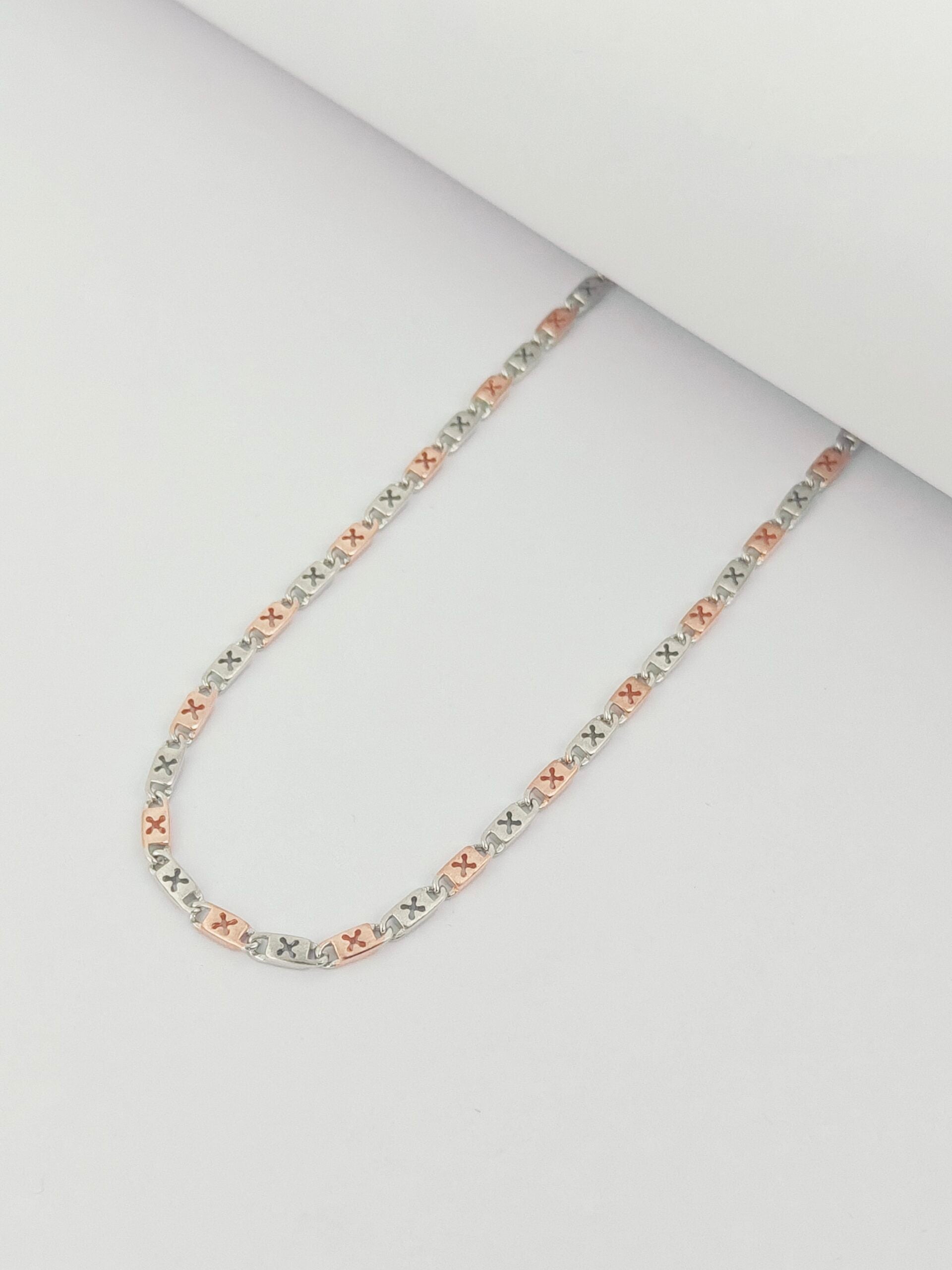 Tri-color chain necklace on a light gray background
