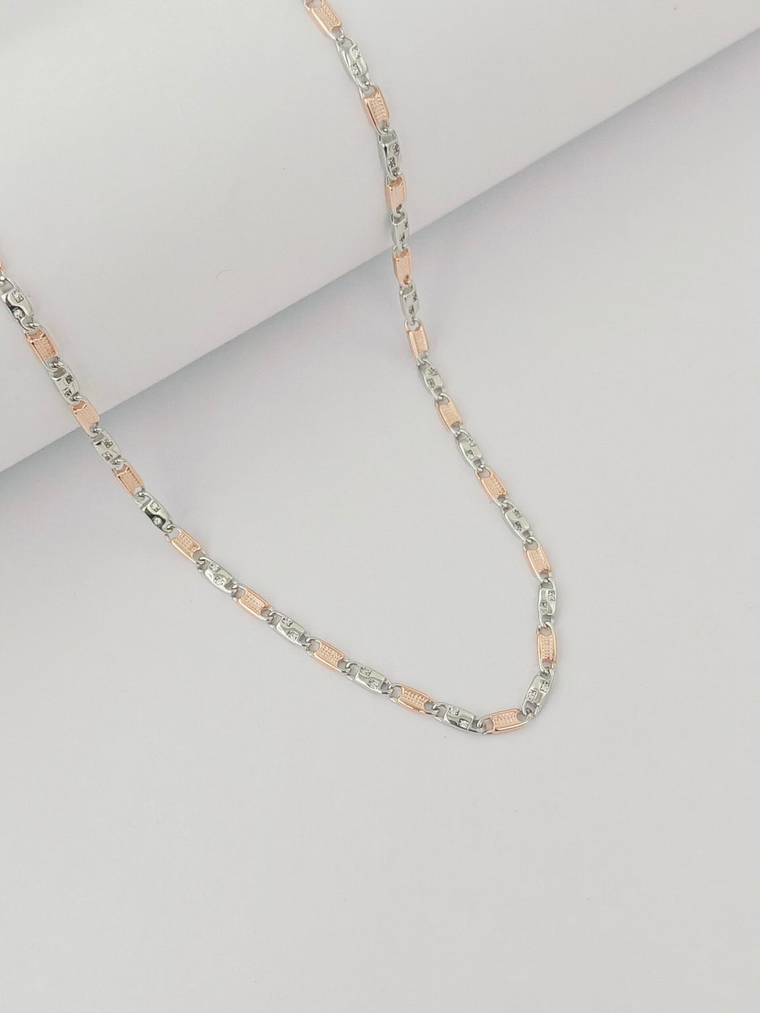 Necklace with alternating pink and silver beads on a light gray background