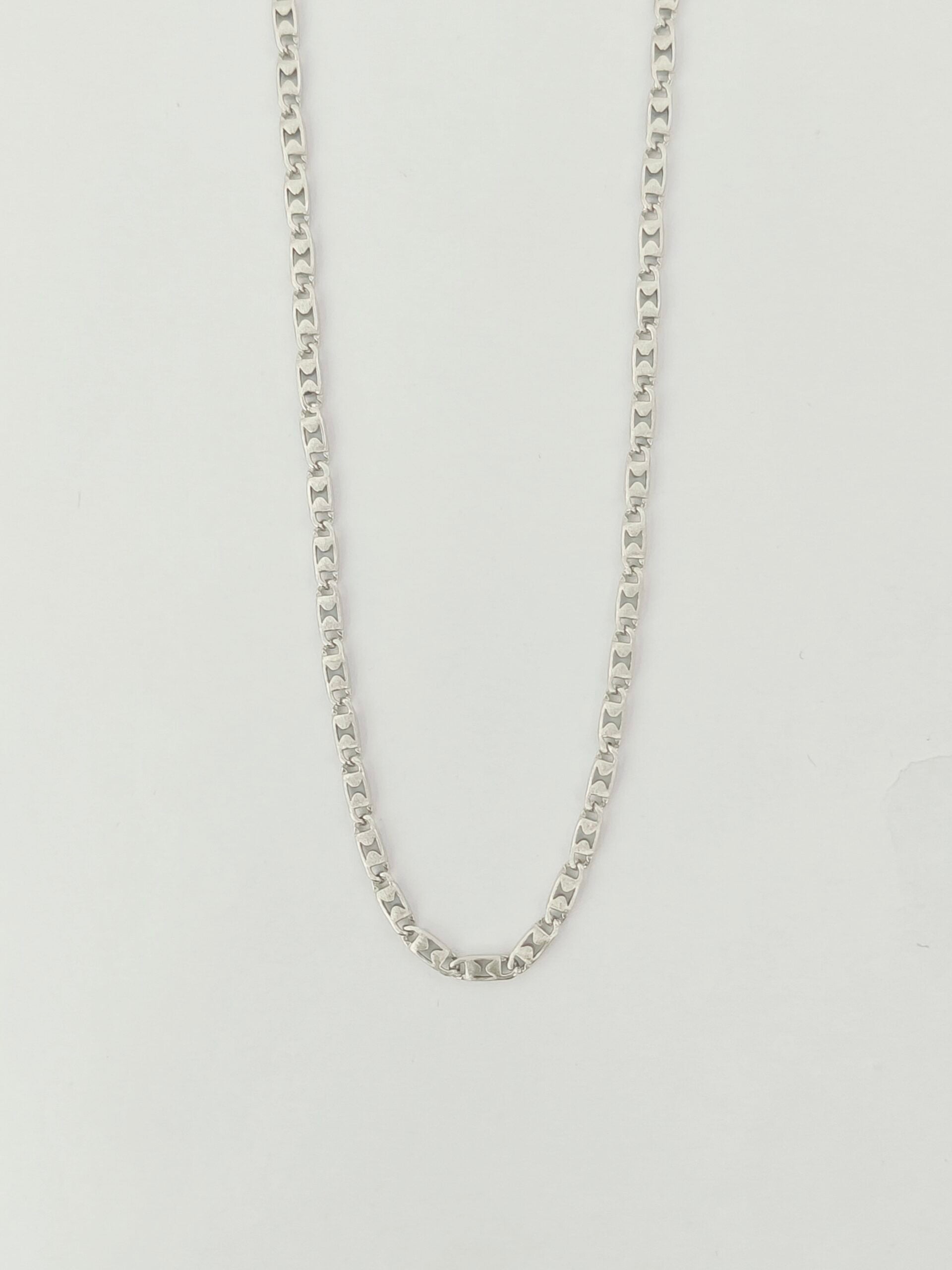 Silver chain necklace on a light gray background