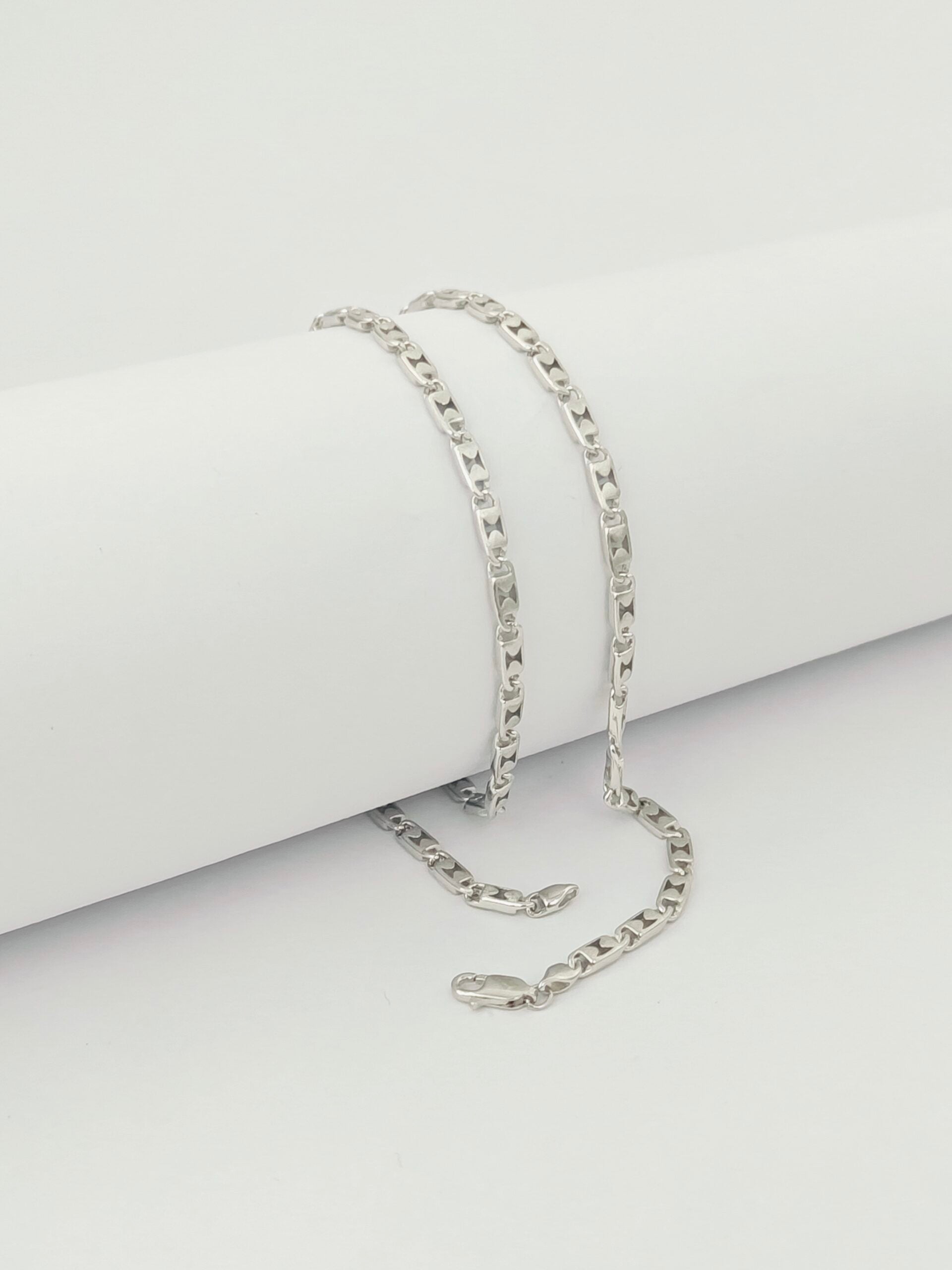 Silver chain necklace on a light gray background