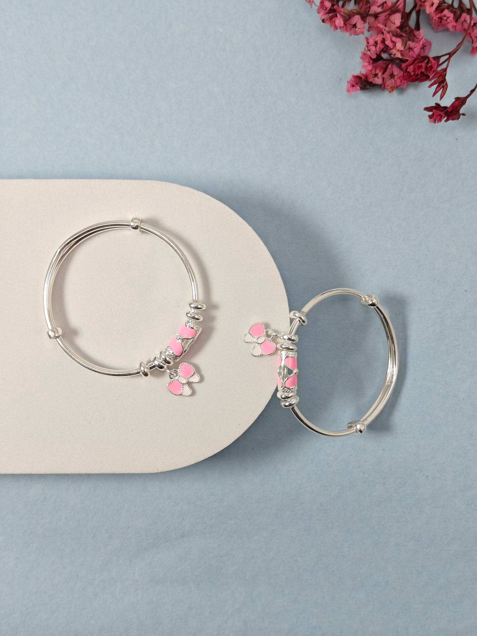 Silver hoop earrings with pink accents on a light blue background