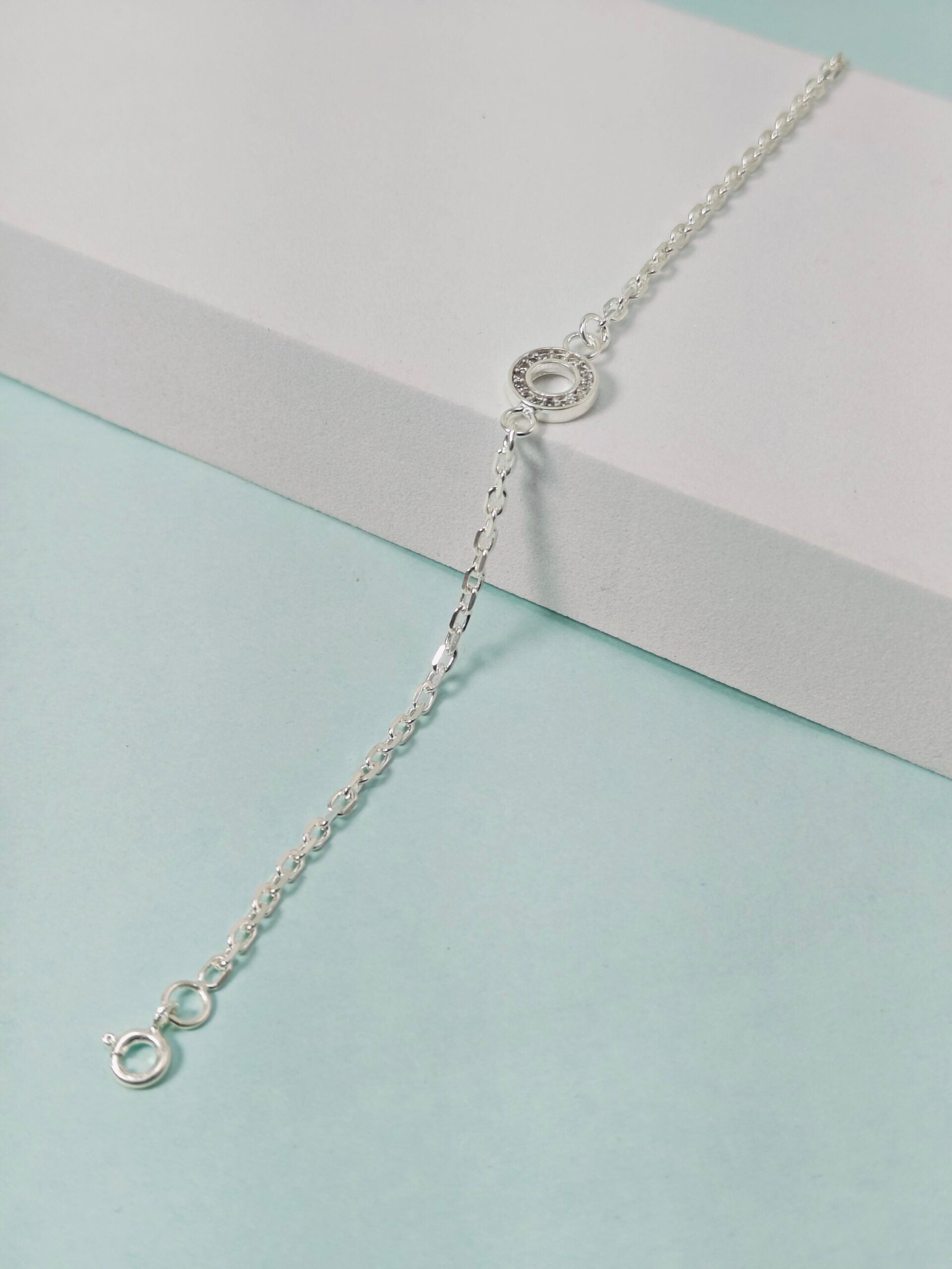 Silver bracelet on a light blue and gray background