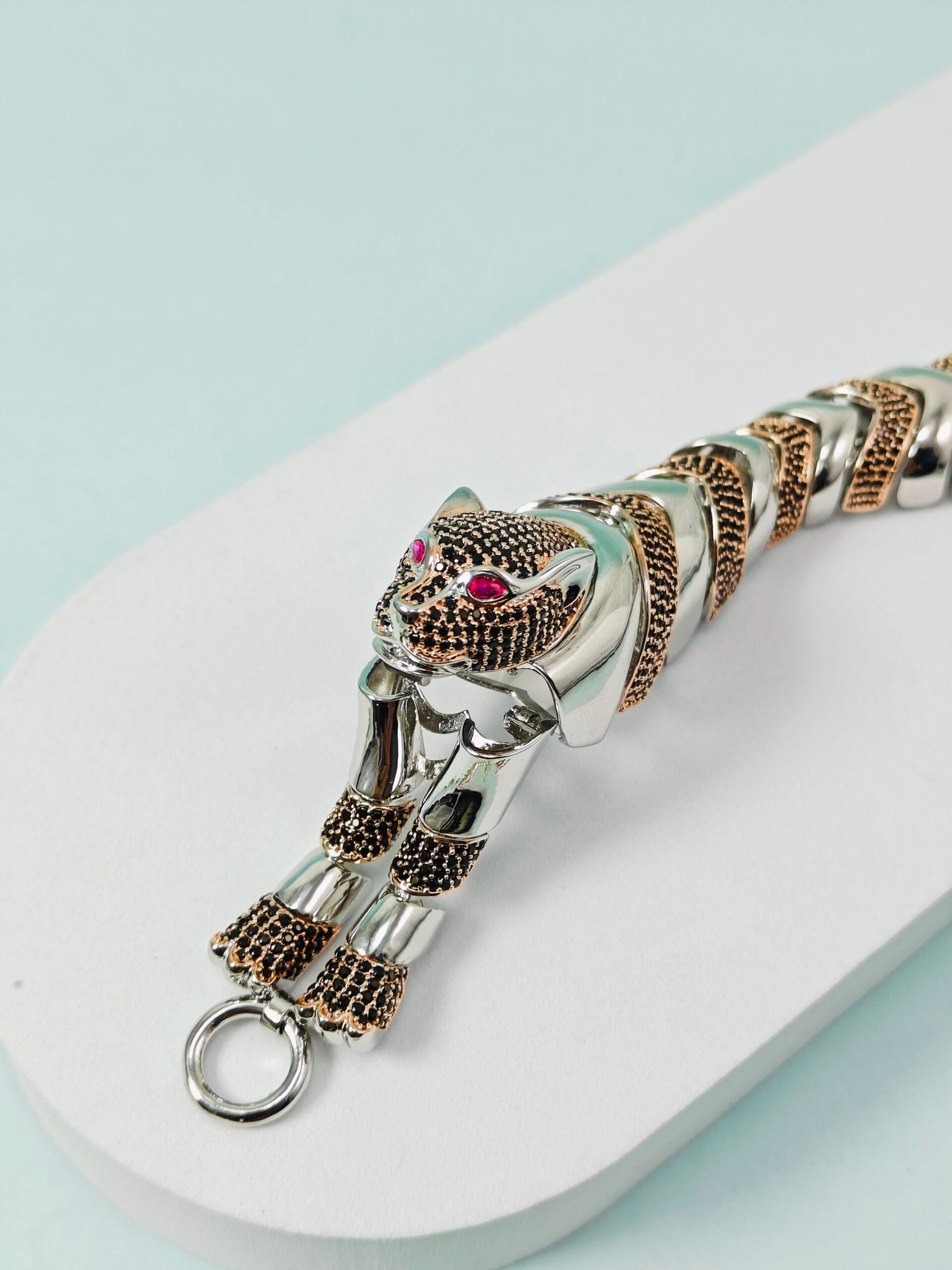 Silver bracelet with a panther design on a white surface