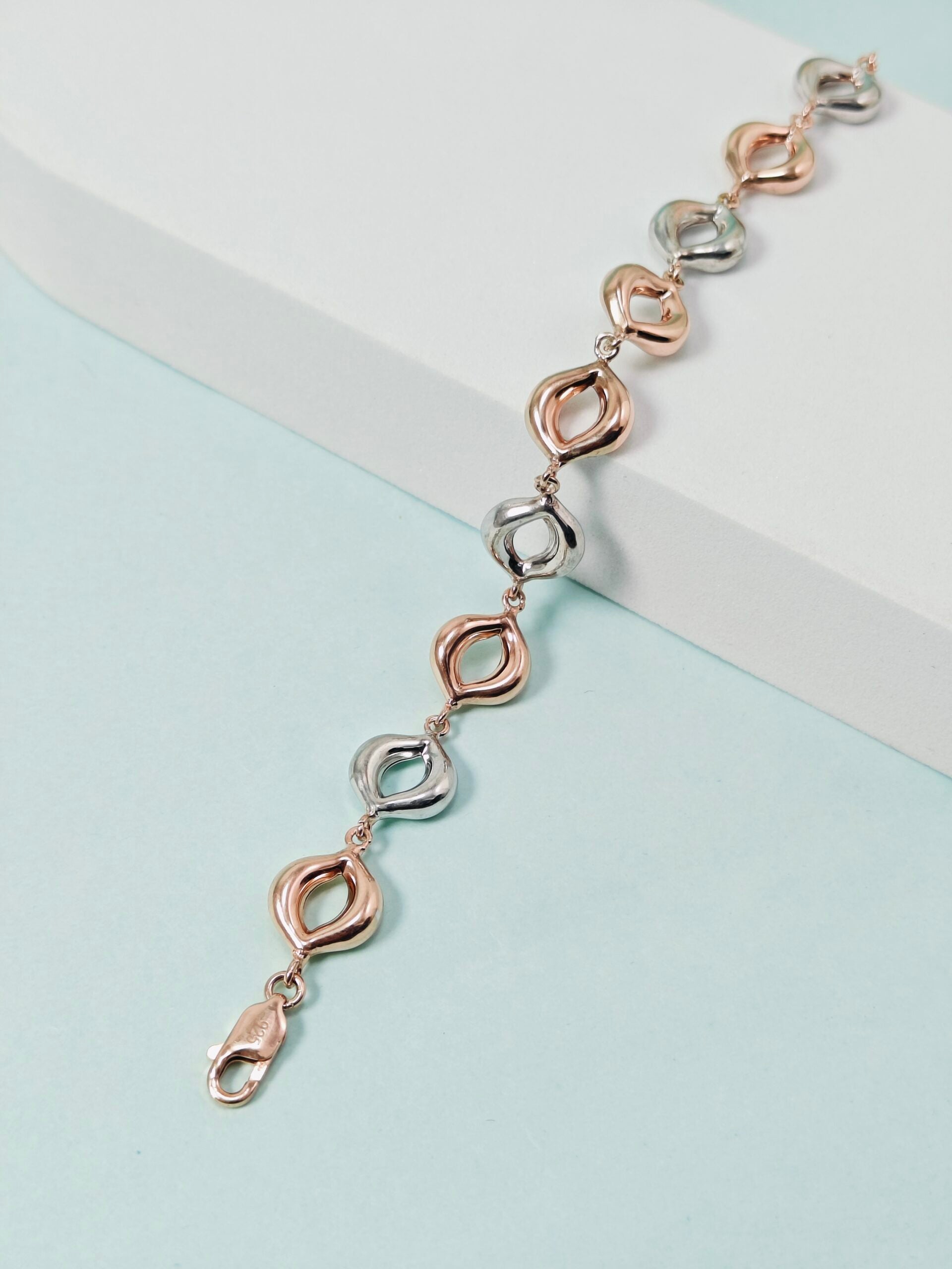Bracelet with rose gold and silver links on a light blue background