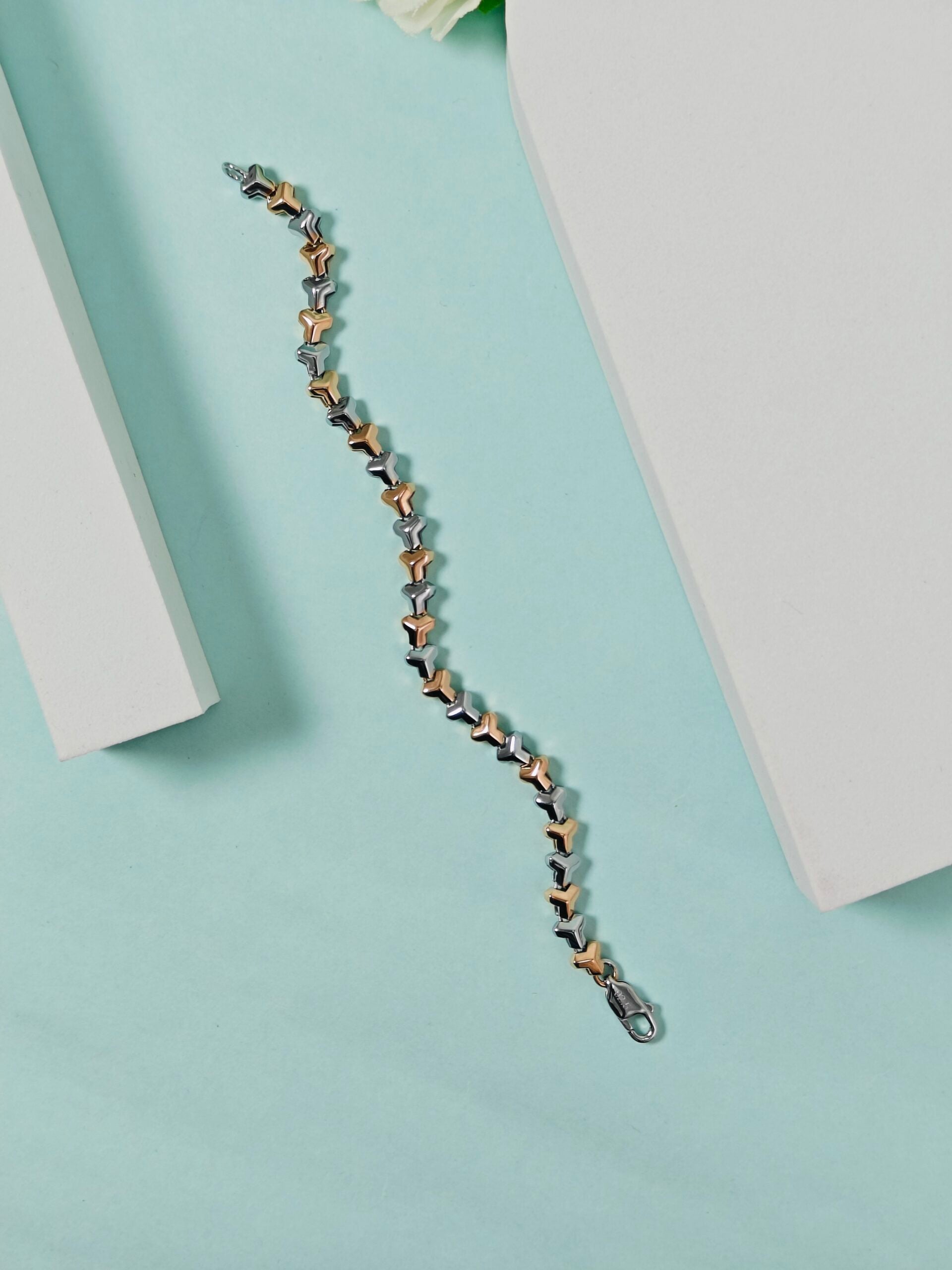 Star-shaped bracelet on a light blue surface with a white box in the background