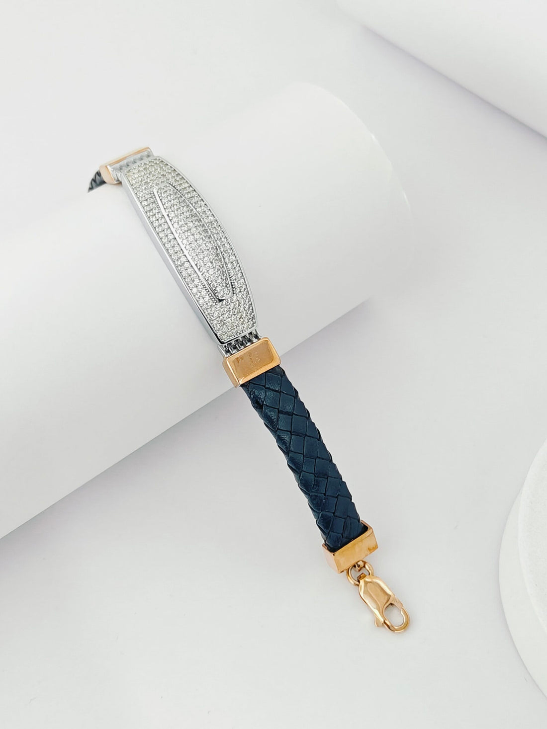 Bracelet with blue braided strap and gold accents on a white background