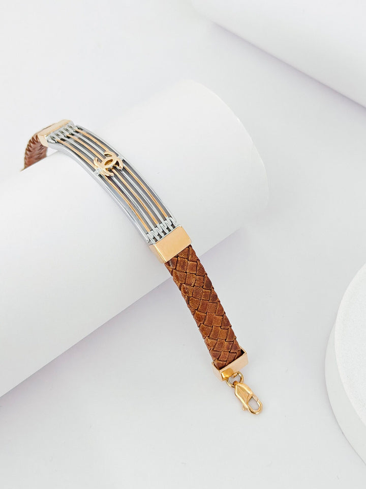 Bracelet with braided brown strap and gold accents on a white background