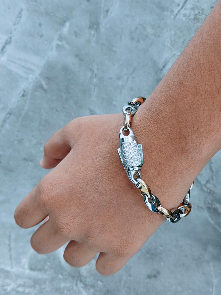 Silver bracelet on a wrist against a gray textured background
