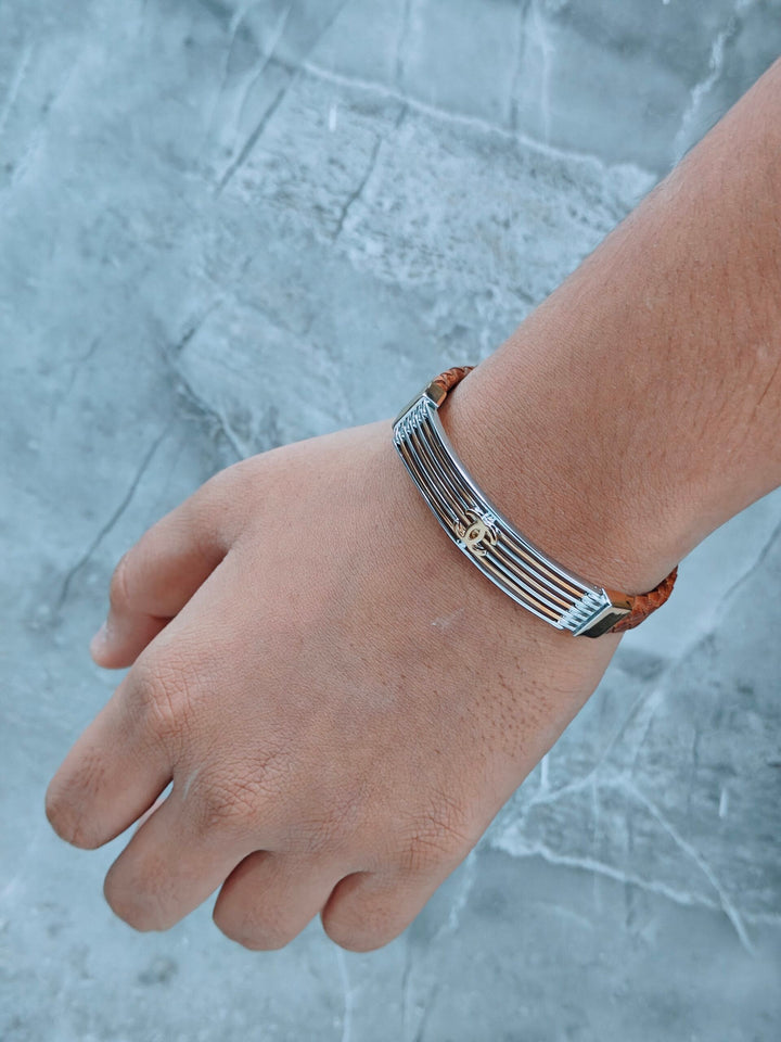 Hand wearing a silver bracelet on a marble surface