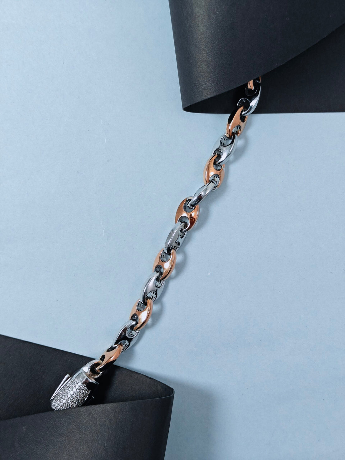 Two-toned chain necklace on a light blue background