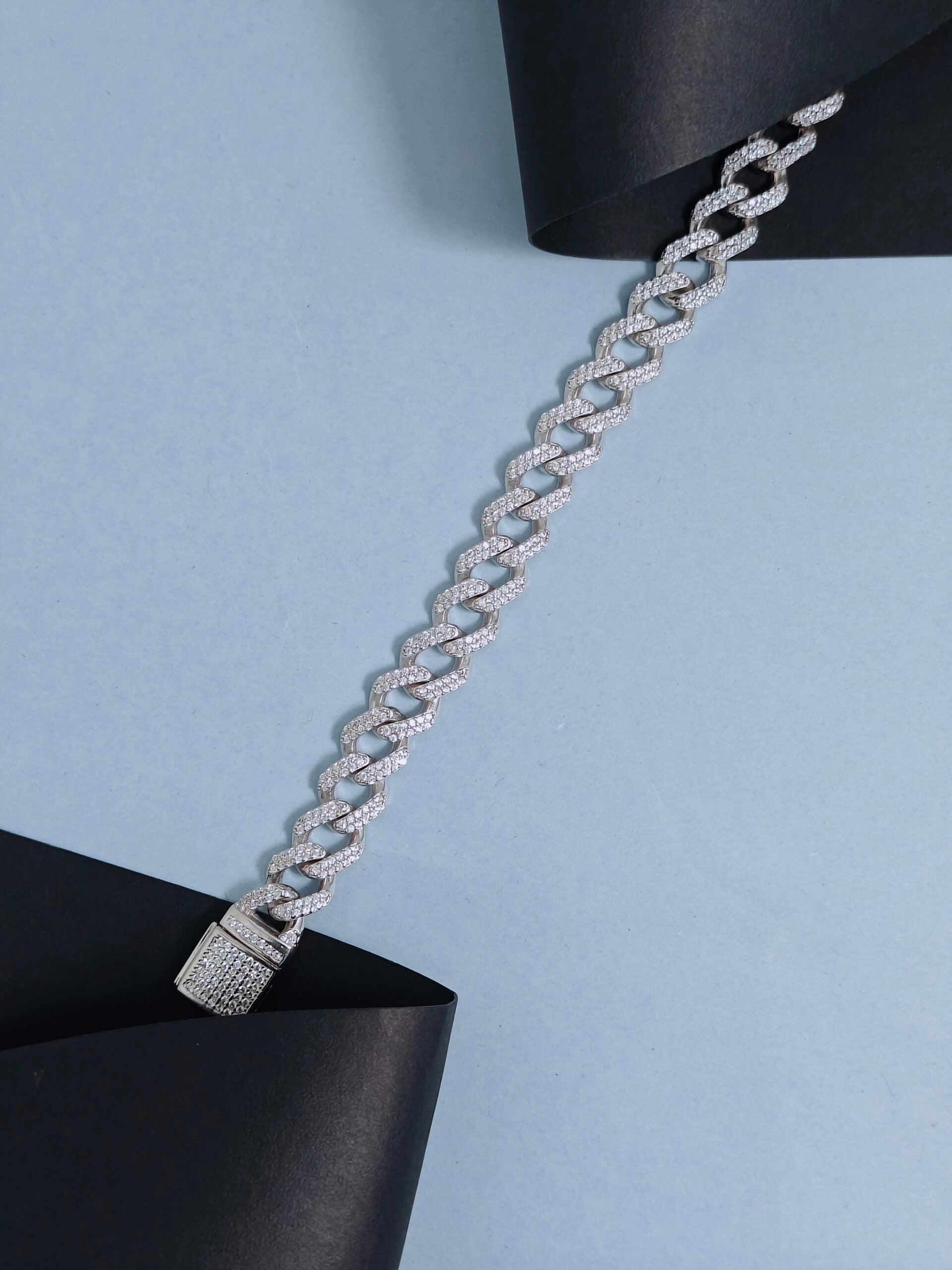 Silver chain bracelet on a light blue background