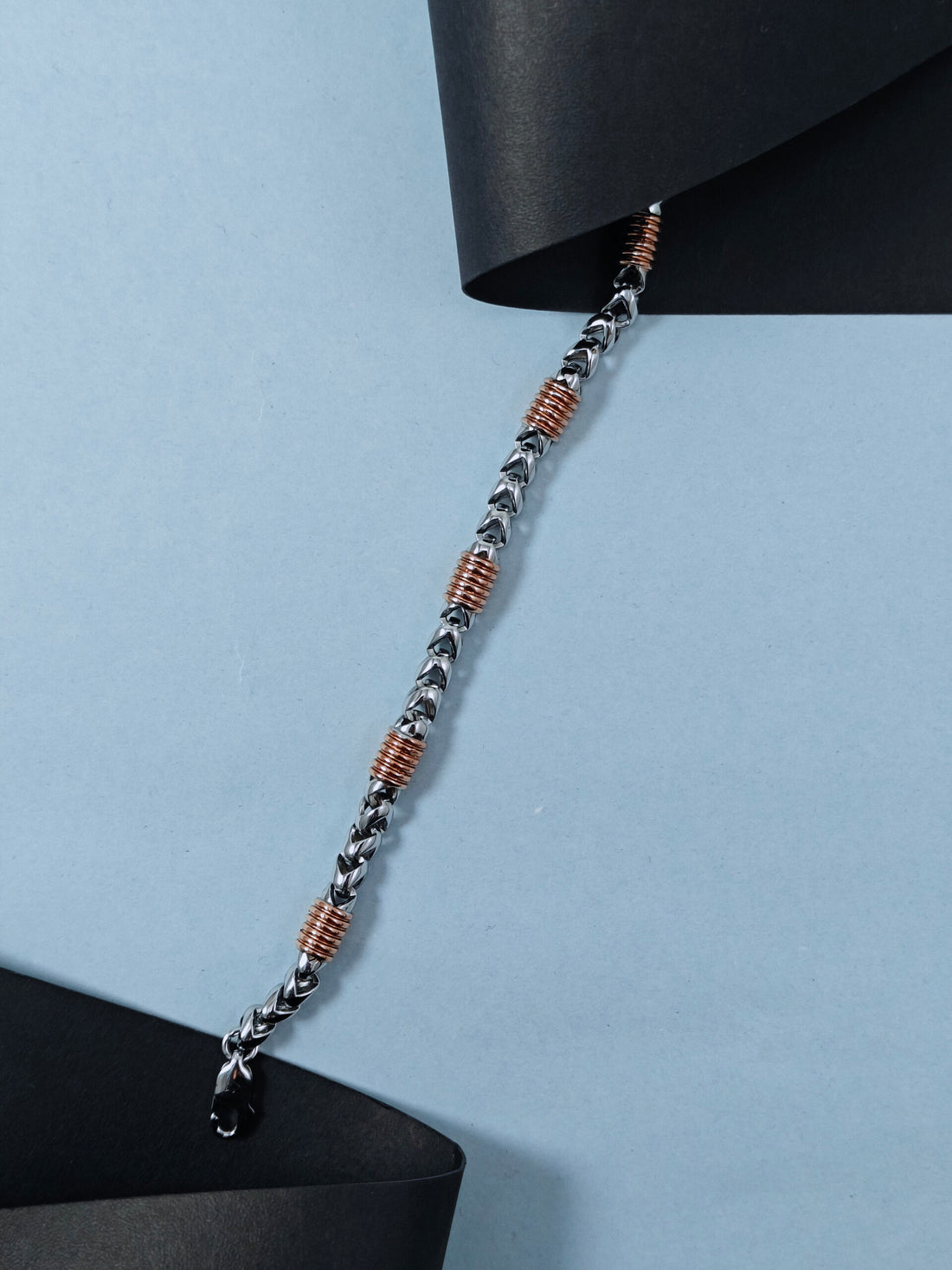 Silver chain with brown beads on a light blue background