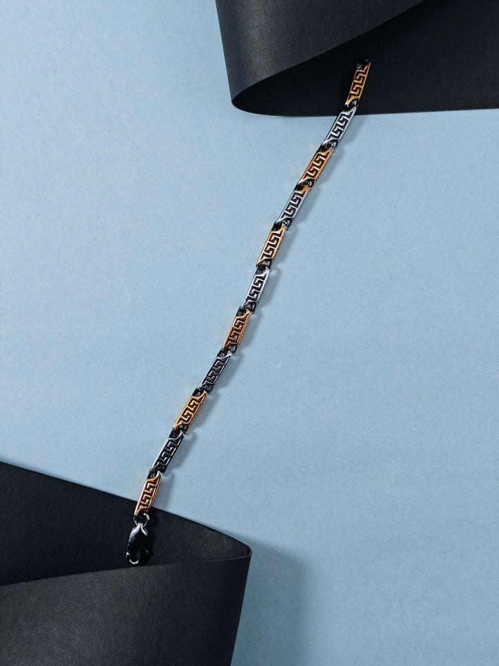 Gold and black chain necklace on a light blue background