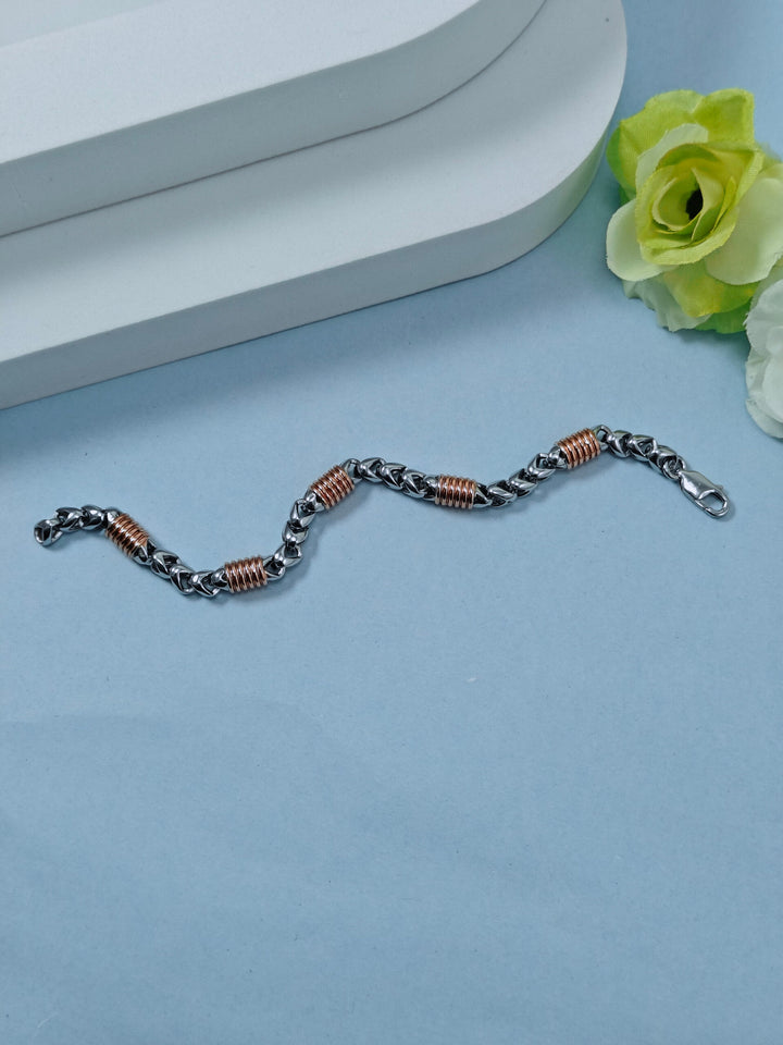 Bracelet with braided design on a light blue surface with a white flower.