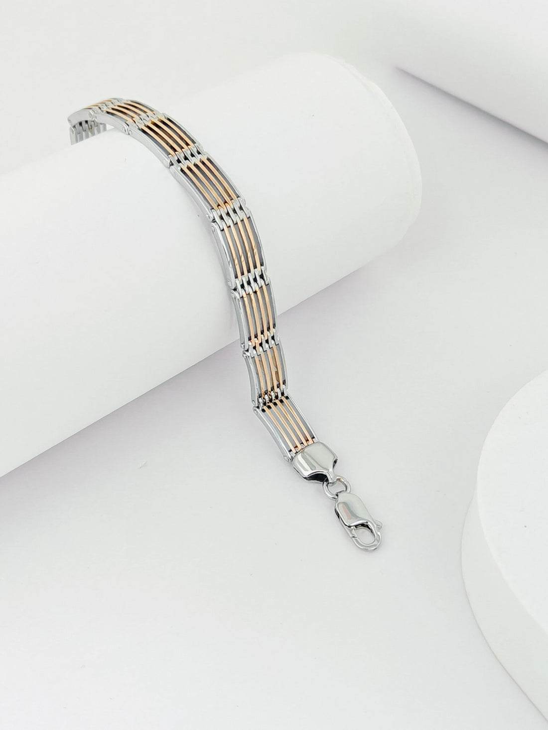 Silver and gold bracelet on a white surface