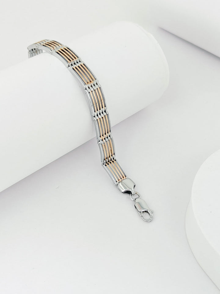 Silver and gold bracelet on a white surface