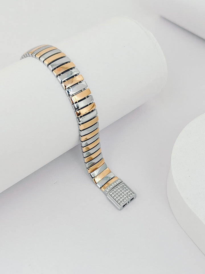 Two-tone watch strap with a diamond-studded end on a white background