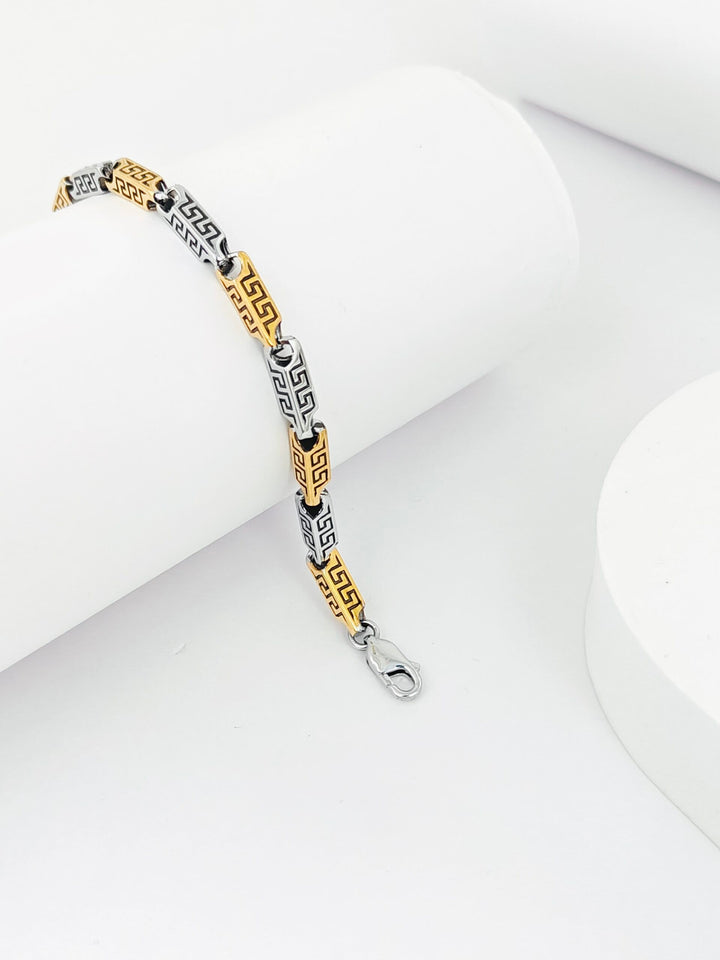 Bracelet with gold and silver design on a white surface