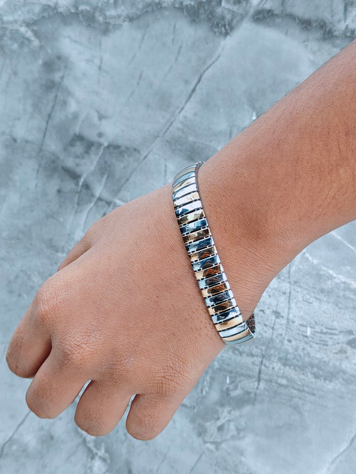 Silver bracelet on a wrist against a gray marble background