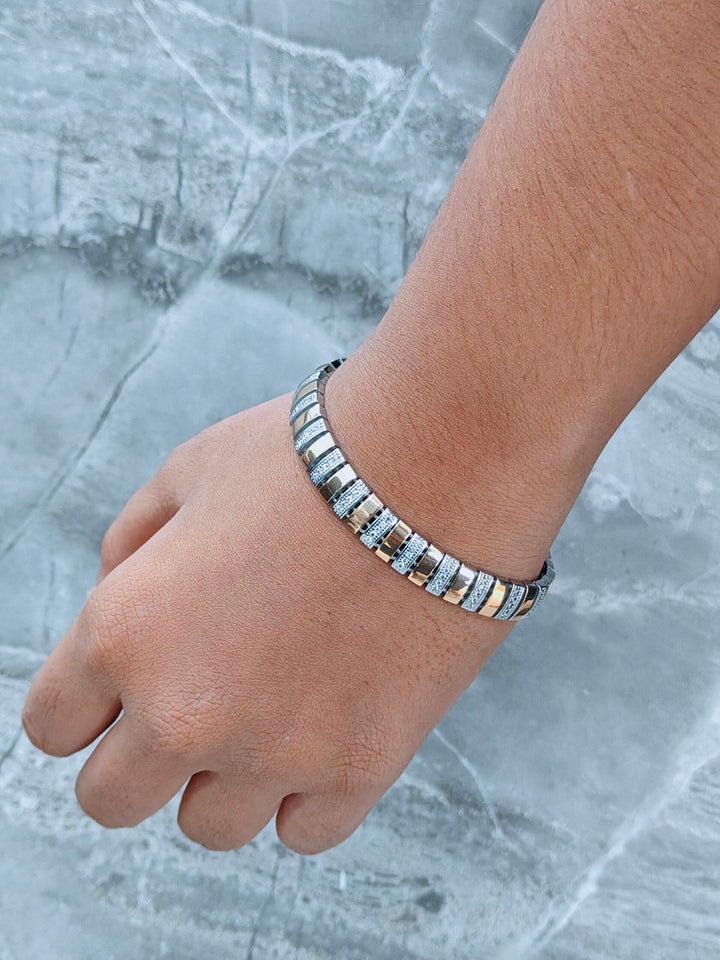 Hand wearing a bracelet on a marble surface