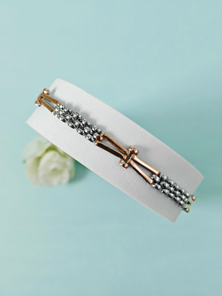 Bracelet with gold and silver beads on a light blue background