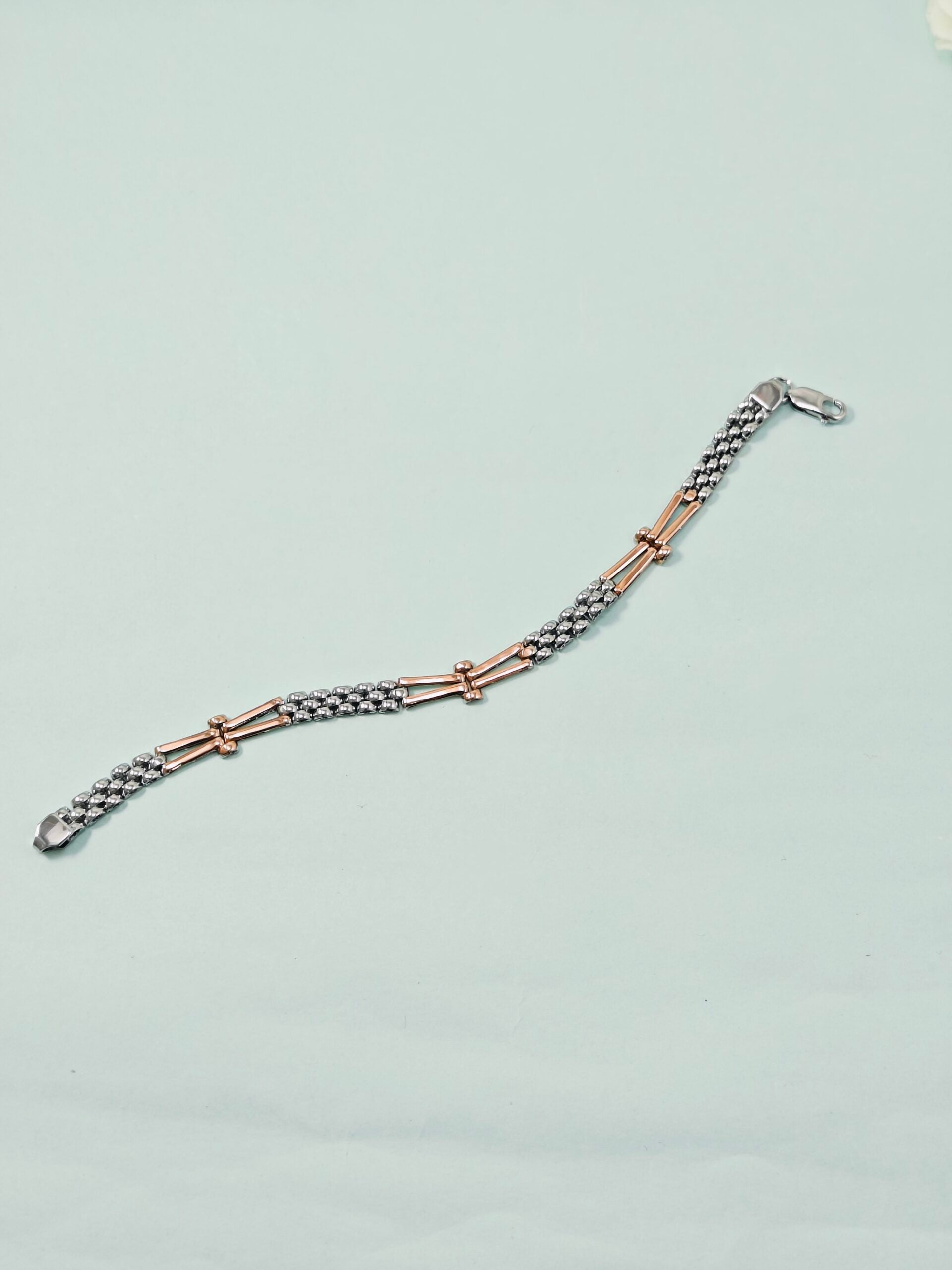 Bracelet with rose gold and silver links on a light gray background