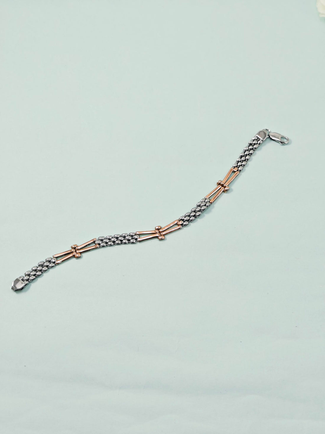 Bracelet with rose gold and silver links on a light gray background