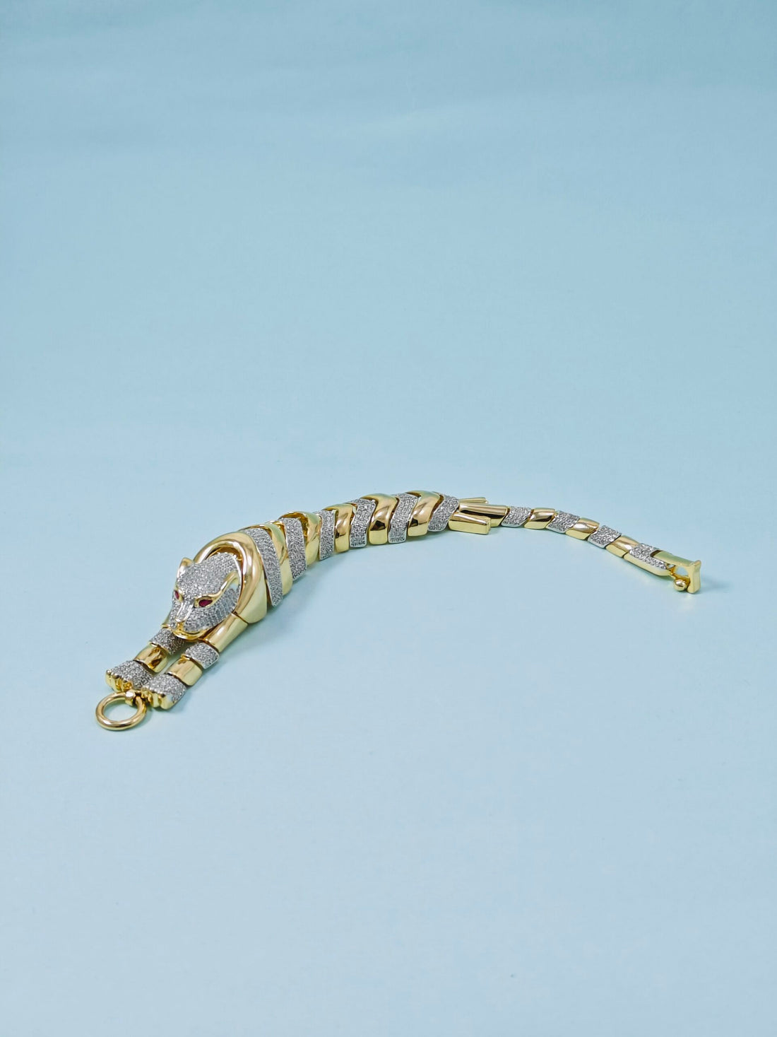 Gold and silver bracelet on a light blue background